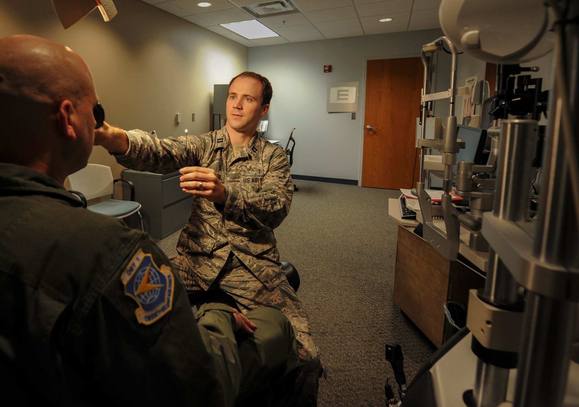 Capt. Cody Peterson, a 19th Aerospace Medicine Squadron optometrist, examines a patient’s eyesight to determine whether or not glasses will be required June 30, 2014, at Little Rock Air Force Base, Ark. Approximately 500 eye examinations are performed by the 19th Medical Group optometry team each month. (U.S. Air Force photo by Airman 1st Class Harry Brexel)