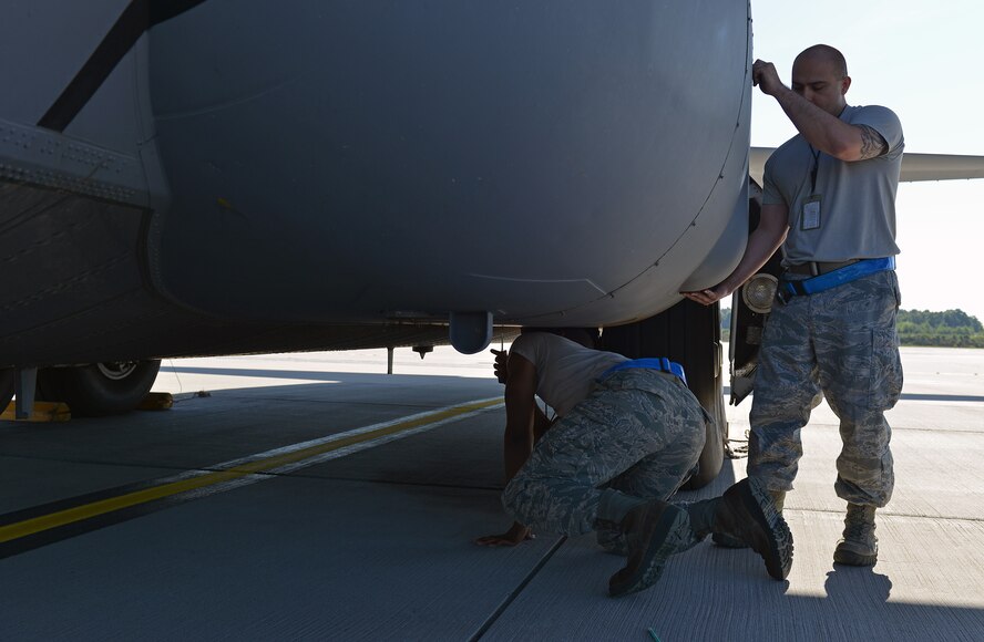 Tech. Sgt. Edwin Huertas, 86th Aircraft Maintenance Squadron propulsion engineer NCOIC, and Senior Airman Ridge Rozier, 86th AMXS hydraulics specialist, take a cover off a C-130J Super Hercules, June 7, 2014, on Ramstein Air Base, Germany. Members of the 86th AMXS work round the clock to ensure aircraft are mission ready at all times.(U.S. Air Force photo by/Senior Airman Holly Mansfield)