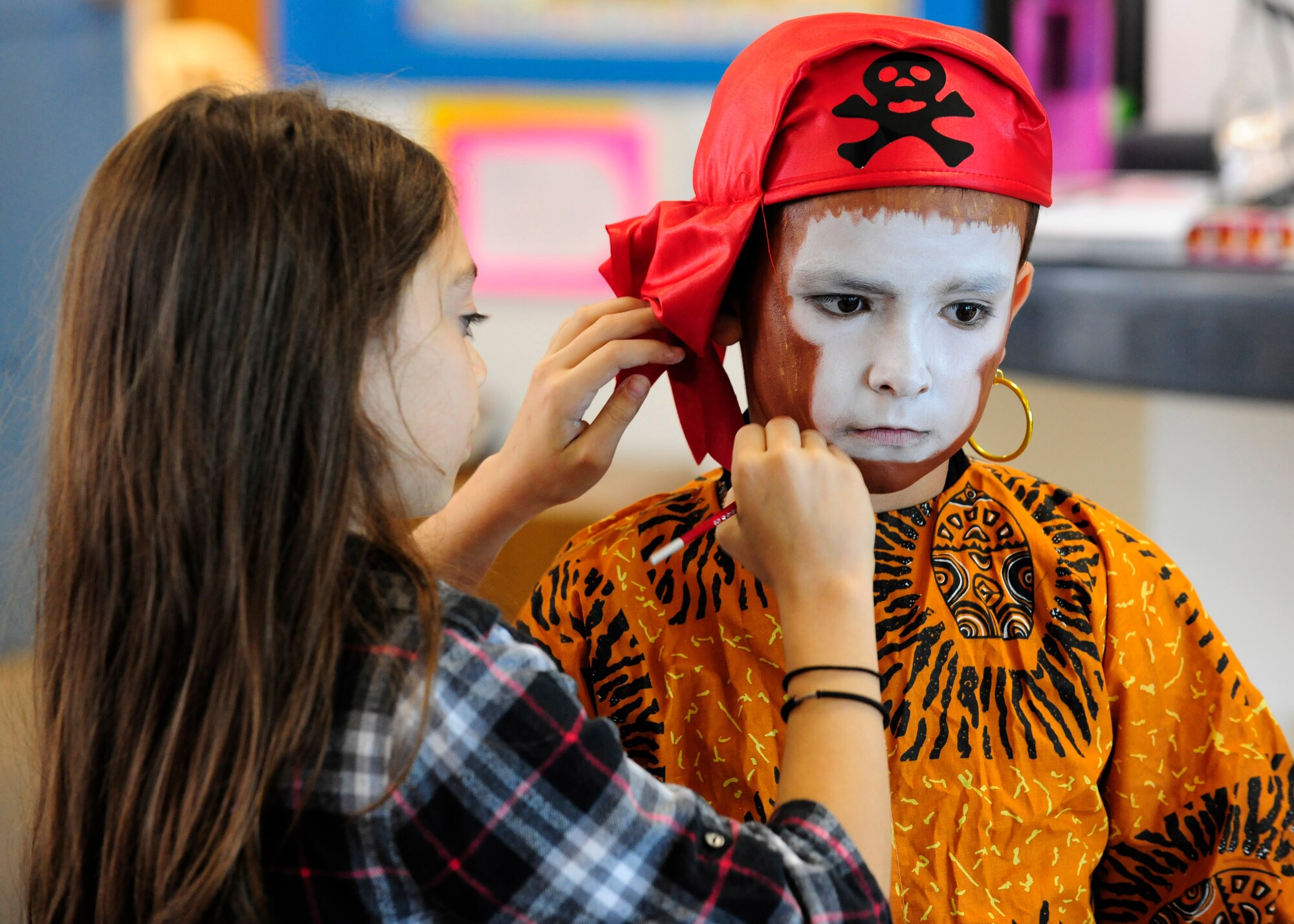 Juliette Tufano paints Giorgio Caporaletti’s face during a dress rehearsal, July 16, 2014, at Aviano Air Base Italy. The rehearsal is part of a summer theater camp for children through the Aviano Youth Programs.  The program offers various summer camps that help military families by offering professional childcare when school is out. Tufano and Caporaletti are both AYP summer camp attendees. (U.S. Air Force photo/Airman 1st Class Ryan Conroy)  