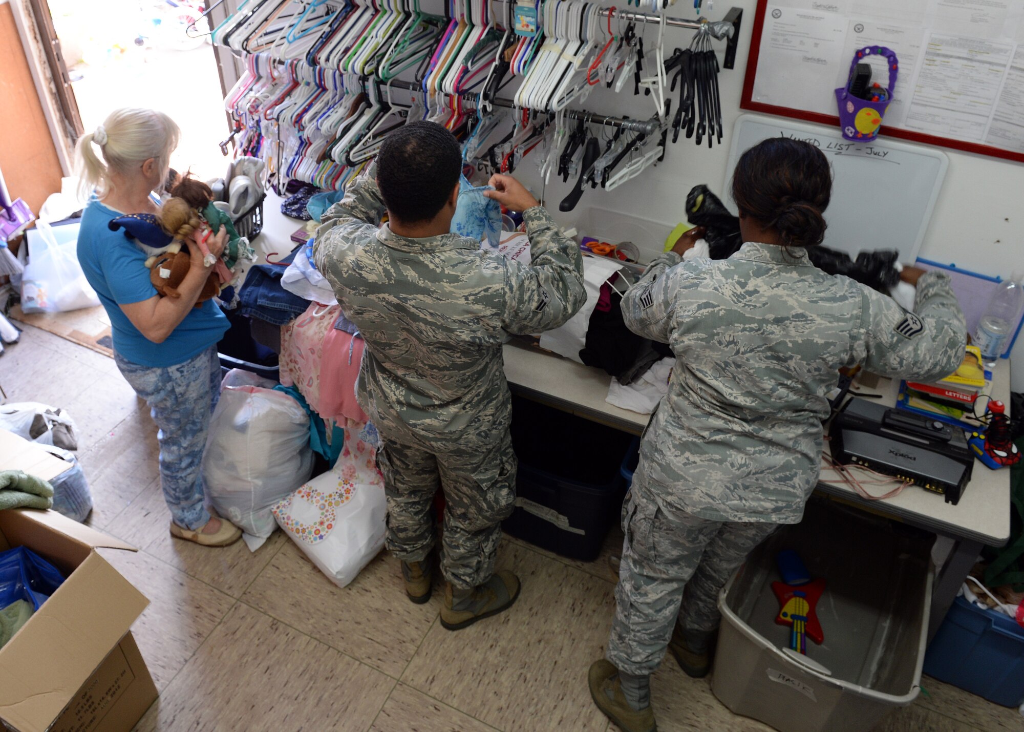 Herta Retterbush, Airman’s Attic volunteer; U.S. Air Force Airman 1st Class Solomon Wright, 606th Air Control Squadron cyber operations technician from Havre de Grace, Md.; and Staff Sgt. Debonnae Cheeks, 606th ACS cyber operations technician from Melrose Park, Ill., sort clothes and other items in the staff room of the Airman's Attic July 15, 2014, at Spangdahlem Air Base, Germany. The staff comprises an all-volunteer force from both military and civilian occupations. (U.S. Air Force photo by Staff Sgt. Daryl Knee/Released)