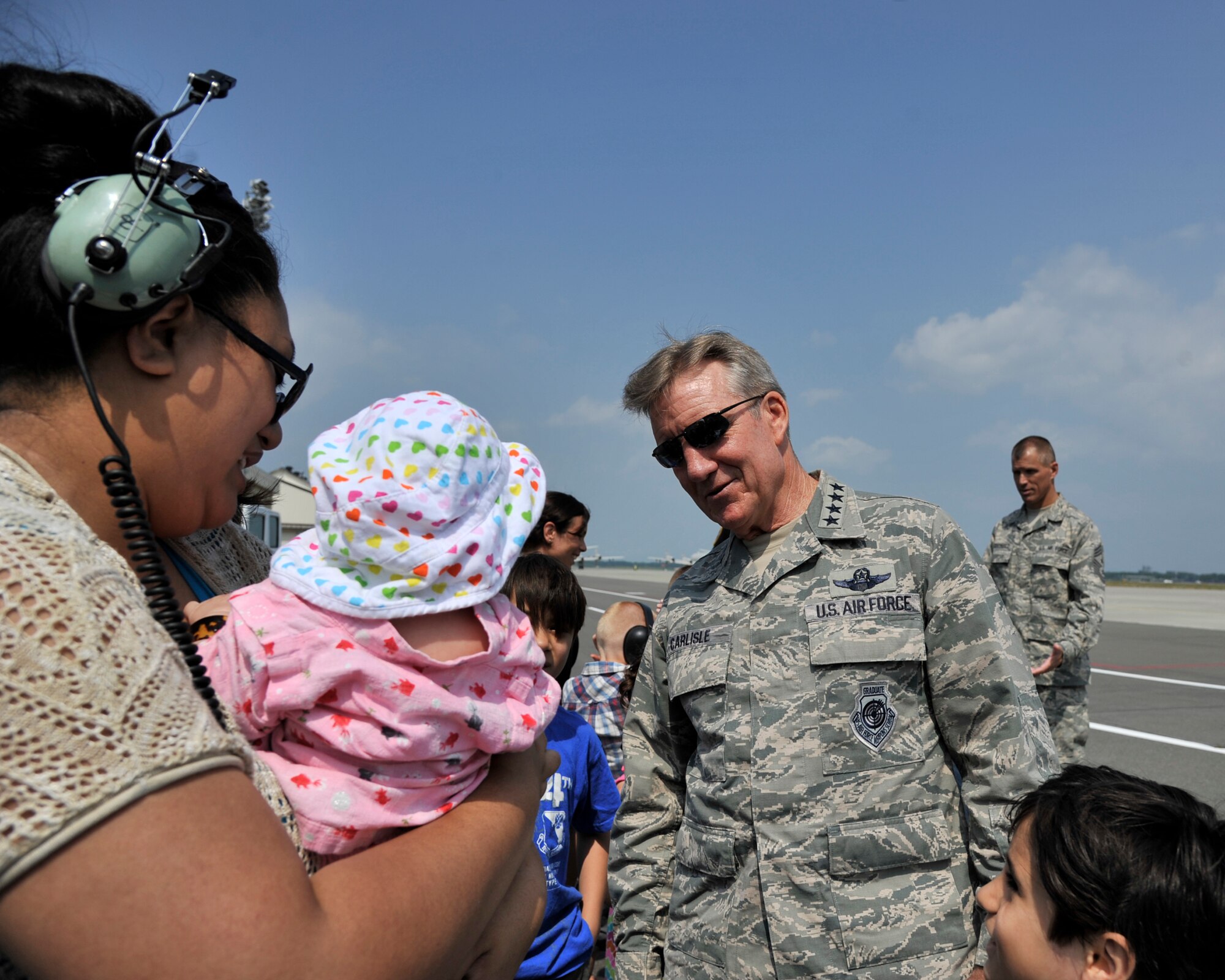 Pacific Air Forces Commander, Gen. Hawk Carlisle takes time to visit the family of an Airman during a flying demonstration at Misawa Air Base, Japan, July 15, 2014. Carlisle’s visit to the base included a breakfast with noncommissioned officers, a PACAF Demonstration Team flyover and an Airmen Call where he spoke of the importance of the Wild Weasels and their role in the defense of the Pacific. (U.S. Air Force photo/Staff Sgt. Tong Duong)