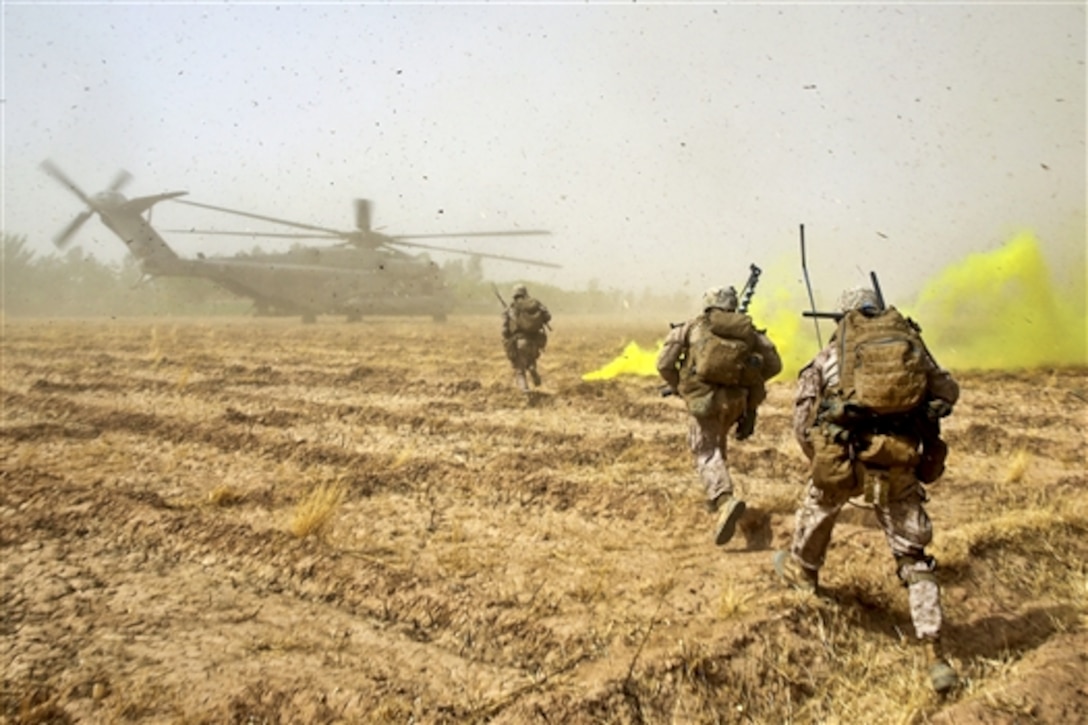 U.S. Marines sprint across a field to load onto a CH-53E Super Stallion helicopter during a mission in Helmand province, Afghanistan, July 4, 2014. The Marines, assigned to Bravo Company, 1st Battalion, 7th Marine Regiment, operated in Gereshk for three days and were involved in numerous engagements with Taliban insurgents. 