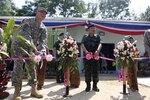 Army Maj. Gen. William Beard, left, deputy commanding general of United States Army Pacific, Royal Thai Army Lt. Gen. Thawatchai Samutsakorn, middle, commanding general of 2nd Army Area, and Payakaphut Pokeaw, right, provincial governor, cut the ceremonial ribbon during the dedication ceremony for the multipurpose building at the Ban Wang Nam Khiao School in Nakhon Ratchasima, Thailand, today. The Royal Thai Army and U.S. Army with the Washington national Guard's 176th Engineer Company constructed the multipurpose building over the course of one month during Exercise Cobra Gold 2012. The exercise improves the capability to plan and conduct combined joint operations, building relationships between partnering nations and improving interoperability across the Asia-Pacific region.