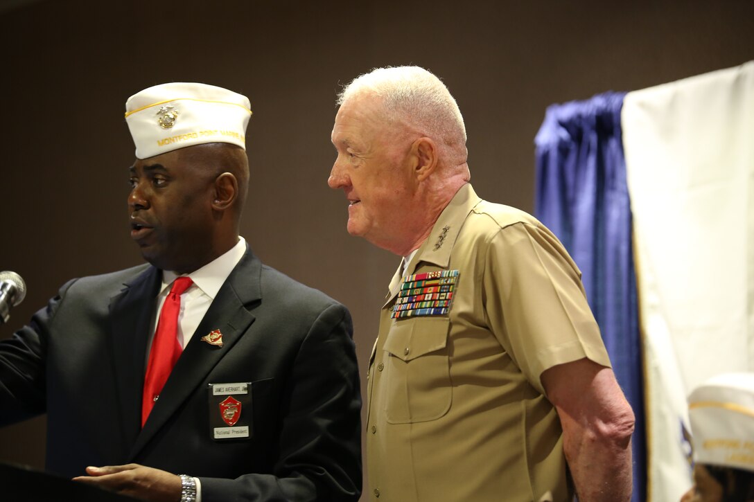 Dr. James T. Averhart, Jr., national president of the Montford Point Marine Association, presents Lt. Gen. Richard P. Mills, commander of Marine Forces Reserve, with a commemorative MPMA challenge coin during the 49th Annual MPMA Conference, July 17, 2014. Mills spoke to chapter leaders, members and original Montford Point Marines in attendance during the opening day of the conference. 