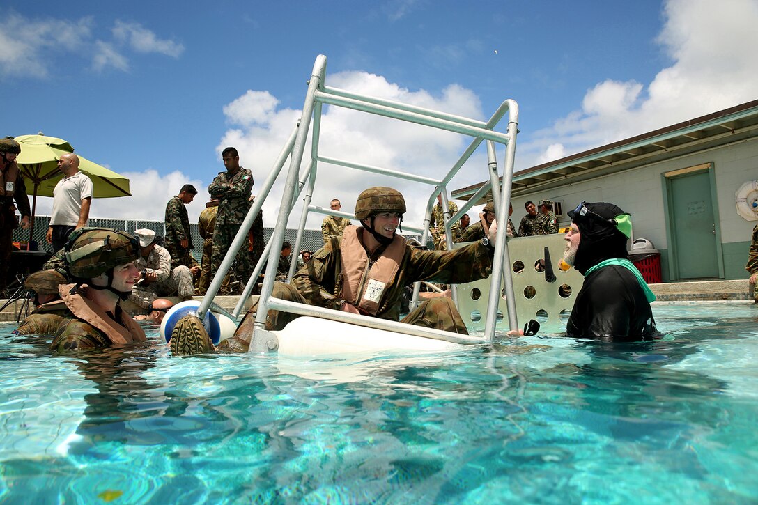 An Australian soldier prepares to use a Shallow Water Egress Trainer, a device designed to simulate an off shore emergency during the Rim of the Pacific Exercise 2014. Training at the pool introduced participants to breathing compressed air and maneuvering upside down underwater to simulate a water survival situation. Twenty-two nations, 49 ships, 6 submarines, more than 200 aircraft and 25,000 personnel are participating in RIMPAC exercise from June 26 through Aug. 1, in and around the Hawaiian Islands. The world's largest international maritime exercise, RIMPAC provides a unique training opportunity that helps participants foster and sustain the cooperative relationships that are critical to ensuring the safety of sea lanes and security on the world's oceans. RIMPAC 2014 is the 24th exercise in the series that began in 1971. (U.S. Marine Corps photo by Sgt. Sarah Dietz/RELEASED)