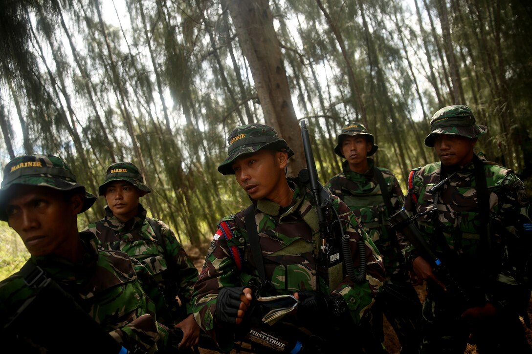 KAHUKU TRAINING AREA, Hawaii - Indonesian marine 1st Sgt. Syahpuetra Hendra (center), a squad leader assigned to 2nd Amphibious Reconnaissance Battalion, prepares his squad to conduct a reconnaissance patrol through the jungle, July 13. The Indonesians, from various units of the Korps Marinir, trained with U.S. Marines assigned to India Company, 3rd Battalion, 3rd Marine Regiment during Rim of the Pacific (RIMPAC) Exercise 2014. Twenty-two nations, 49 ships and six submarines, more than 200 aircraft and 25,000 personnel are participating in RIMPAC from June 26 to Aug. 1 in and around the Hawaiian Islands and Southern California. The world's largest international maritime exercise, RIMPAC provides a unique training opportunity that helps participants foster and sustain the cooperative relationships that are critical to ensuring the safety of sea lanes and security on the world's oceans. RIMPAC 2014 is the 24th exercise in the series that began in 1971. (U.S. Marine Corps photo by Cpl. Matthew Callahan/Released)