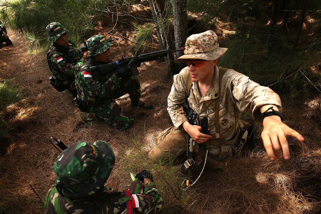 KAHUKU TRAINING AREA, Hawaii - U.S. Marine Cpl. Joseph Josleyn, liaison for the Indonesian marines, talks with their squad leader on a reconnaissance patrol to discuss routes through the jungle. The Indonesians, from various units of the Korps Marinir, trained with U.S. Marines assigned to India Company, 3rd Battalion, 3rd Marine Regiment during Rim of the Pacific (RIMPAC) Exercise 2014, July 13. Twenty-two nations, 49 ships and six submarines, more than 200 aircraft and 25,000 personnel are participating in RIMPAC from June 26 to Aug. 1 in and around the Hawaiian Islands and Southern California. The world's largest international maritime exercise, RIMPAC provides a unique training opportunity that helps participants foster and sustain the cooperative relationships that are critical to ensuring the safety of sea lanes and security on the world's oceans. RIMPAC 2014 is the 24th exercise in the series that began in 1971. (U.S. Marine Corps photo by Cpl. Matthew Callahan/Released)