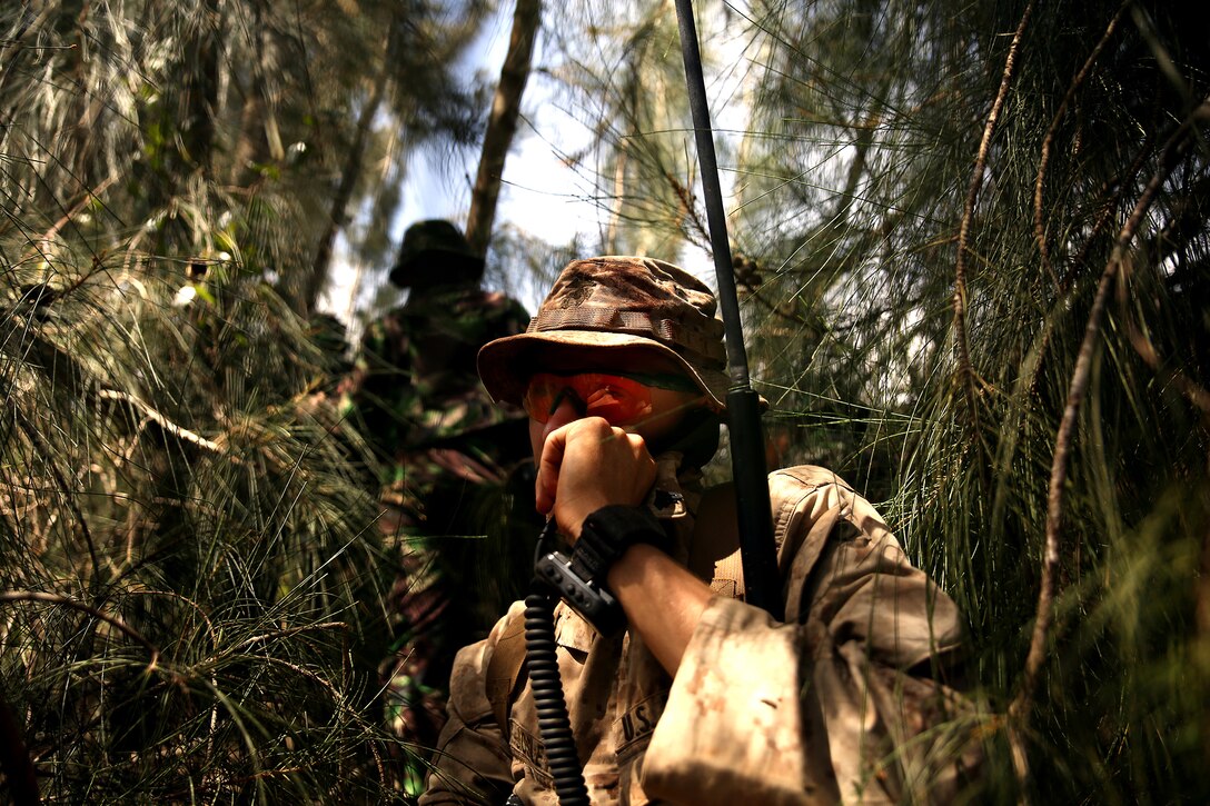 KAHUKU TRAINING AREA, Hawaii - U.S. Marine Cpl. Joseph Josleyn, liaison for the Indonesian marines, calls Company Landing Team 1 command operations center for a position report while on a reconnaissance patrol. The Indonesians, from various units of the Korps Marinir, trained with U.S. Marines assigned to India Company, 3rd Battalion, 3rd Marine Regiment during Rim of the Pacific (RIMPAC) Exercise 2014, July 13. Twenty-two nations, 49 ships and six submarines, more than 200 aircraft and 25,000 personnel are participating in RIMPAC from June 26 to Aug. 1 in and around the Hawaiian Islands and Southern California. The world's largest international maritime exercise, RIMPAC provides a unique training opportunity that helps participants foster and sustain the cooperative relationships that are critical to ensuring the safety of sea lanes and security on the world's oceans. RIMPAC 2014 is the 24th exercise in the series that began in 1971. (U.S. Marine Corps photo by Cpl. Matthew Callahan/Released)