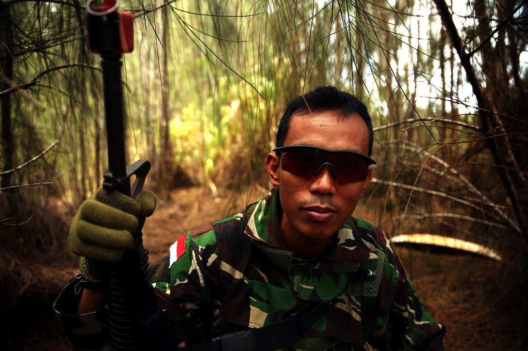 KAHUKU TRAINING AREA, Hawaii -  Lance Cpl. Muhammad Rois poses for a photo while his squad is halted on a reconnaissance patrol to search for opposing forces. The Indonesians, from various units of the Korps Marinir, trained with U.S. Marines assigned to India Company, 3rd Battalion, 3rd Marine Regiment during Rim of the Pacific (RIMPAC) Exercise 2014, July 13. Twenty-two nations, 49 ships and six submarines, more than 200 aircraft and 25,000 personnel are participating in RIMPAC from June 26 to Aug. 1 in and around the Hawaiian Islands and Southern California. The world's largest international maritime exercise, RIMPAC provides a unique training opportunity that helps participants foster and sustain the cooperative relationships that are critical to ensuring the safety of sea lanes and security on the world's oceans. RIMPAC 2014 is the 24th exercise in the series that began in 1971. (U.S. Marine Corps photo by Cpl. Matthew Callahan/Released)