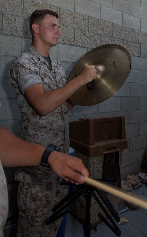 Cpl. Tony Overkamp, a percussionist with the 3rd Marine Aircraft Wing Band, plays the cymbals during a homecoming at the Visiting Aircraft Line aboard Marine Corps Air Station Miramar, Calif., July 16. Other services the band provides include: ceremonial performances such as change of command and retirement ceremonies, parades, events and special performances by the rock band and party band.