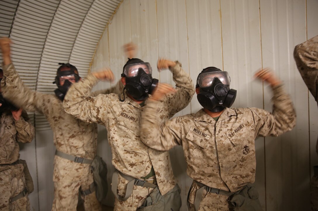 Recruits of India Company, 3rd Battalion, give the "gas, gas, gas" signal signifying a chemical enviorment, while conducting a Confidence Chamber exercise at Edson Range on Marine Corps Base Camp Pendleton, July 14.