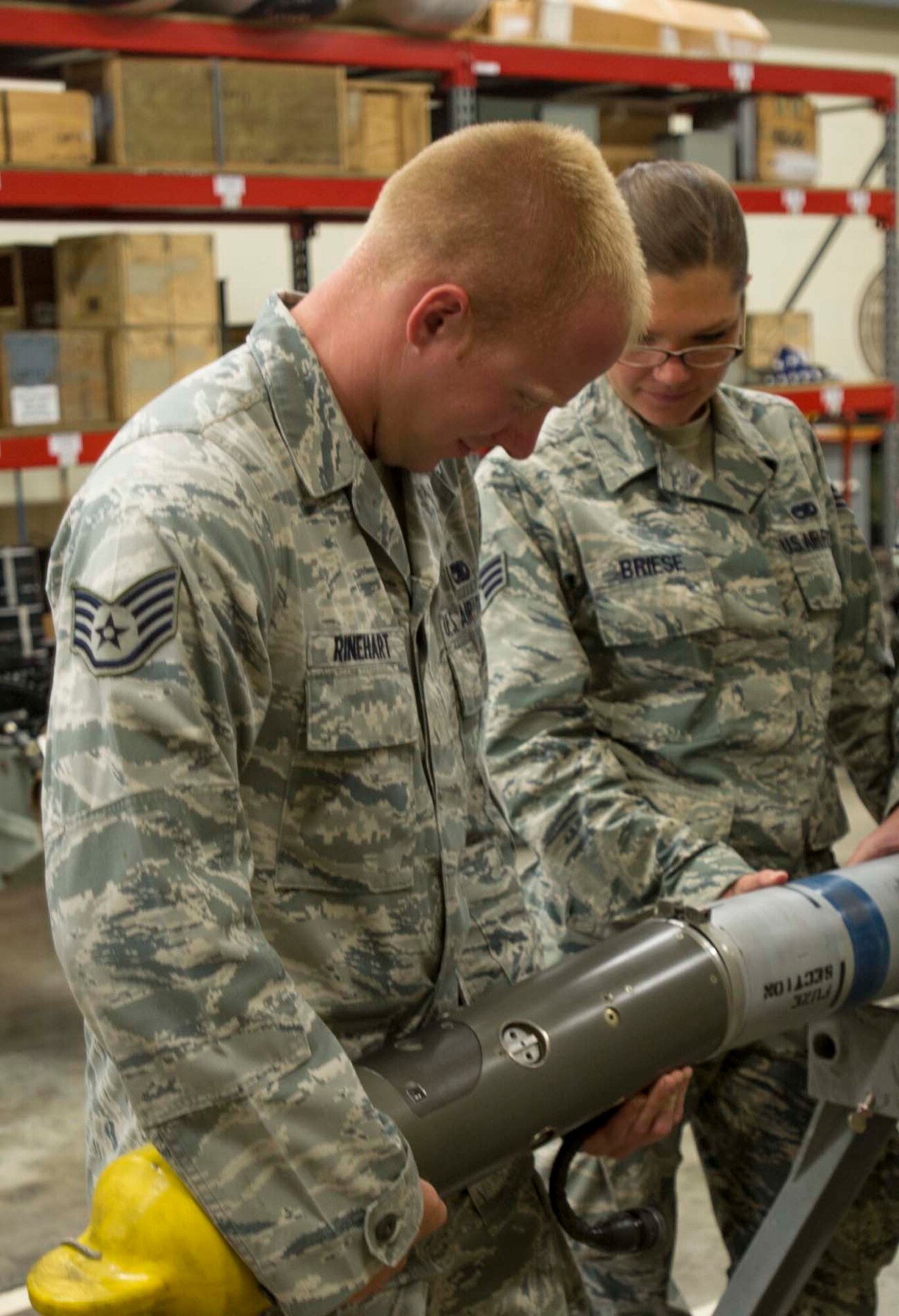 Staff Sgt. Paul Rinehart, 391st Fighter Squadron Munitions Flight munitions inspector, and Senior Airman Elizabeth Briese, 391st FS Munitions Flight munitions controller, remove a Captive Air Training Missile 9-M head July 17, 2014. Both Rinehart and Briese are deployed to Joint Base Pearl Harbor-Hickam, Hawaii, from Mountain Home Air Force Base, Idaho, in support of Rim of the Pacific 2014. RIMPAC is a U.S. Pacific Command-hosted biennial multinational maritime exercise designed to foster and sustain international cooperation on the security of the world's oceans. (U.S. Air Force photo by Tech. Sgt. Terri Paden)