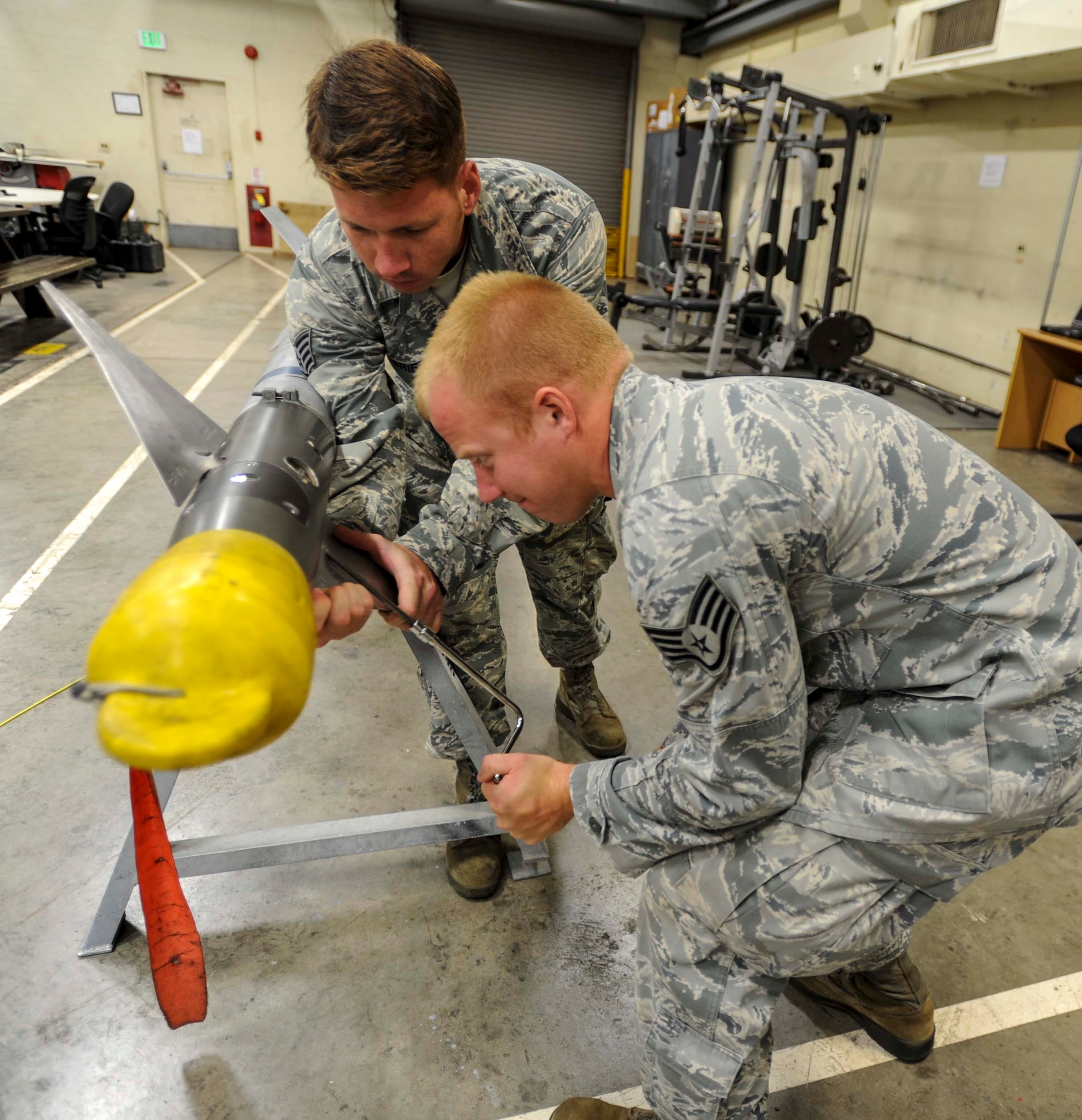 Staff Sgt. Travis Briese, 391st Fighter Squadron Munitions Flight equipment maintainer, holds a Captive Air Training Missile 9-M fin in place as Staff Sgt. Paul Rinehart, 391st FS Munitions Flight munitions inspector, uses a speed wrench to remove the fin from the guidance section of the missile head July 17, 2014. Both Briese and Rinehard are deployed to Joint Base Pearl Harbor-Hickam, Hawaii, from Mountain Home Air Force Base, Idaho, in support of Rim of the Pacific 2014. RIMPAC is a U.S. Pacific Command-hosted biennial multinational maritime exercise designed to foster and sustain international cooperation on the security of the world's oceans. (U.S. Air Force photo by Tech. Sgt. Terri Paden)
