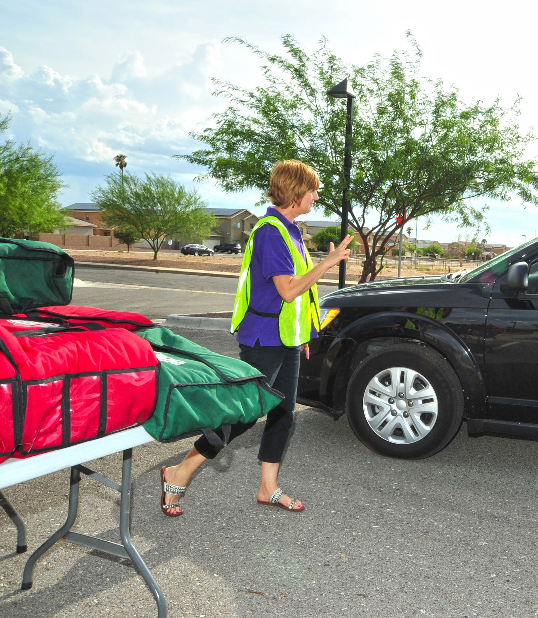 Mandy Petzer, Soaring Heights Communities receptionist, takes an order for two pizzas during the Drive-Thru Pizza Night held at the Welcome Home Center at Davis-Monthan Air Force Base, Ariz., July 16, 2014.  The discount pizza event is hosted by Soaring Heights on the third Thursday of each month.  (U.S. Air Force Photo by Airman 1st Class Chris Massey/Released)