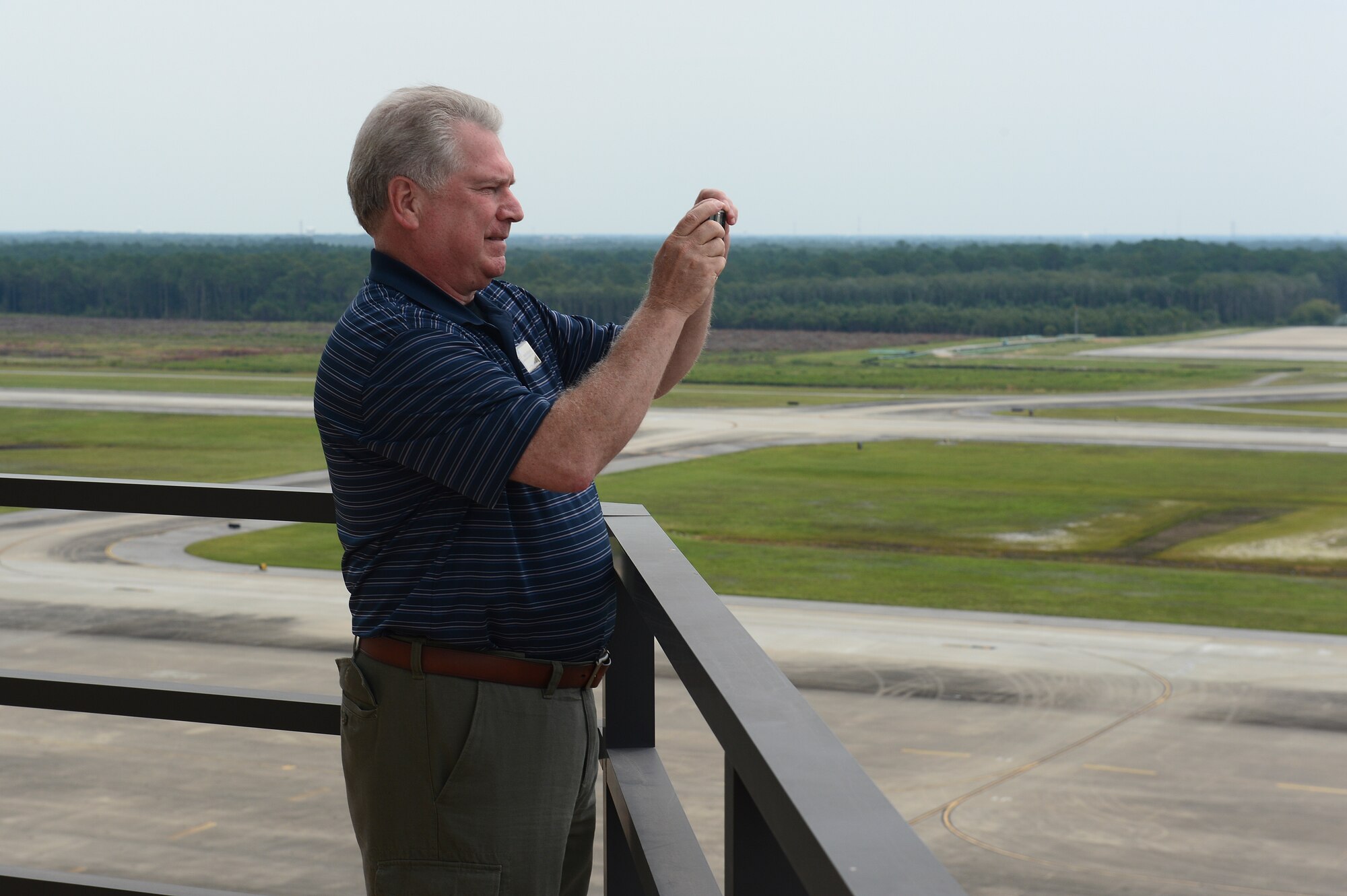 Brian Ekedahl, Emerald Coast Waterfront Rescue Mission executive director, takes a photo on the catwalk of the air traffic control tower at Hurlburt Field, Fla., July 18, 2014. Ekedahl is the honorary commander for Chief Master Sgt. Jeffery Mayberry, 1st Special Operations Wing command chief. (U.S. Air Force photo/Airman 1st Class Jeff Parkinson)