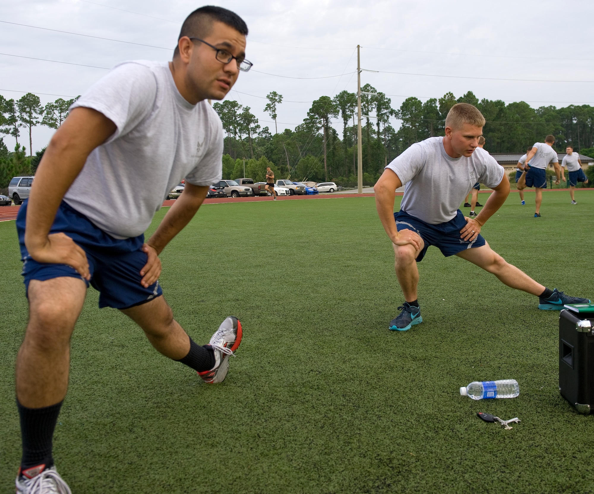 Airman 1st Class Joseph Olachea, left, 1st Special Operations Civil Engineer Squadron operations manager and Senior Airman Adam Baker, 1st SOCES water and fuels systems maintainer, stretch before beginning their physical fitness training on Hurlburt Field, Fla., July 18, 2014. Some common injuries involve the legs, which include hamstring and ankle sprains, knee injuries and overuse injuries such as runner’s knee and plantar fasciitis (U.S. Air Force photo/Senior Airman Kentavist P. Brackin)