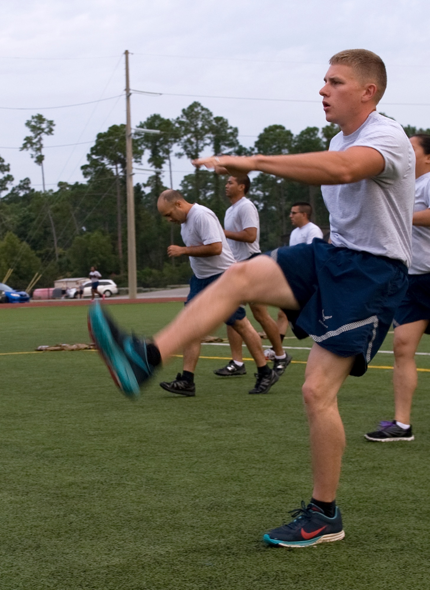 Senior Airman Adam Baker, 1st Special Operations Civil Engineer Squadron water and fuels systems maintainer, and other Airmen execute dynamic stretching before beginning physical fitness training on Hurlburt Field, Fla., July 18, 2014. Dynamic stretching uses controlled leg movements to loosen up muscles and increase heart rate, body temperature and blood flow. (U.S. Air Force photo/Senior Airman Kentavist P. Brackin)