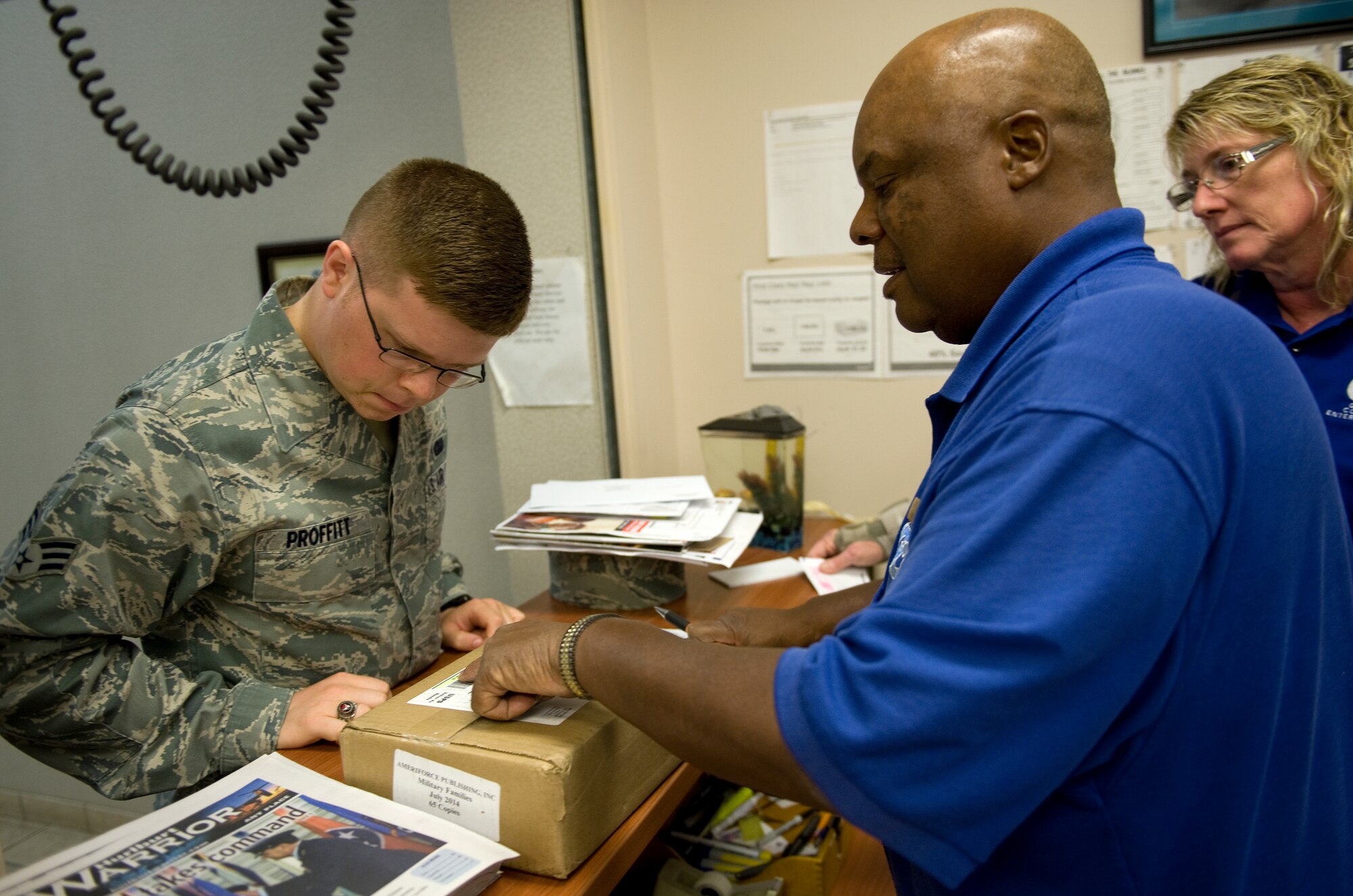 James Bacon, Hurlburt Field Official Mail Center mail clerk, helps an Airman verify the serial number for official mail slated for picked up from the post office on Hurlburt Field, Fla., July 16, 2014. Official mail is identifiable by serial numbers and can only be retrieved by personnel authorized to handle official mail. (U.S. Air Force photo/Senior Airman Kentavist P. Brackin)