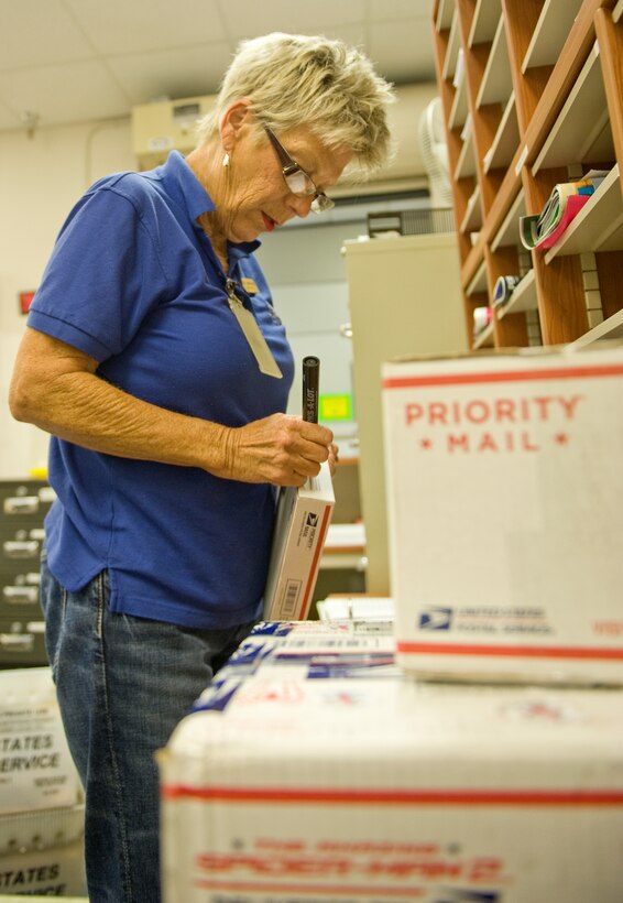 Patty Armstrong, Postal Service Center mail clerk, logs and marks all incoming personnel mail at the post office on Hurlburt Field, Fla., July 16, 2014. The Hurlburt Field Post Office receives up to four shipments of mail every day, categorized as either personnel or official mail. (U.S. Air Force photo/Senior Airman Kentavist P. Brackin)