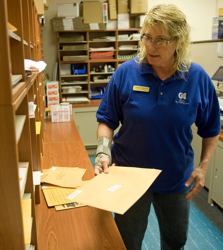 Pamela Nabors, Hurlburt Field Official Mail Center assistant program manager, searches for the placement of an outgoing piece of mail at the post office on Hurlburt Field, Fla., July 16, 2014. All official mail sent to the same base are packed inside a larger envelope to help save money on shipping and handling. (U.S. Air Force photo/Senior Airman Kentavist P. Brackin)