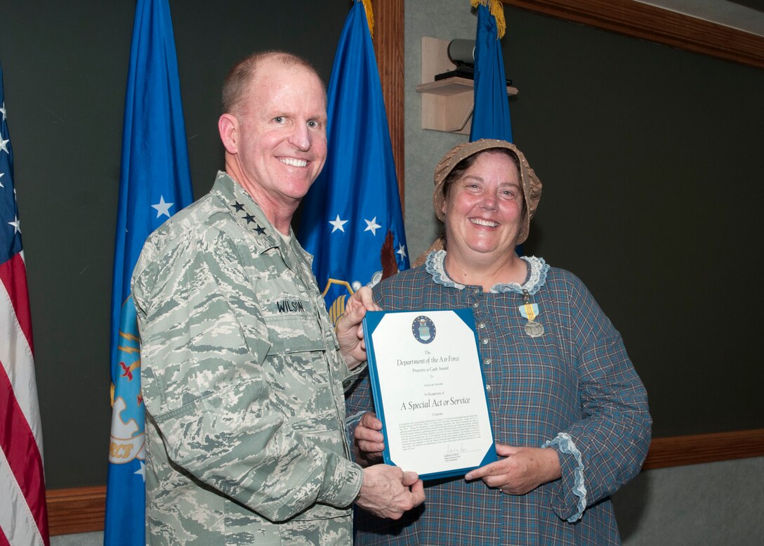 Lt. Gen. Stephen Wilson, Commander, Air Force Global Strike Command, Barksdale Air Force Base, La., presents the Special Act or Service Award to Paula Taylor, Warren ICBM & Heritage Museum director, July 18, 2014, at F.E. Warren Air Force Base. Taylor was presented the award for her continuous support of the ICBM mission. She helped reintroduce parts determined obsolete by the Air Force Logistical System back into active service saving the Air Force, Department of Defense and taxpayers millions of dollars.