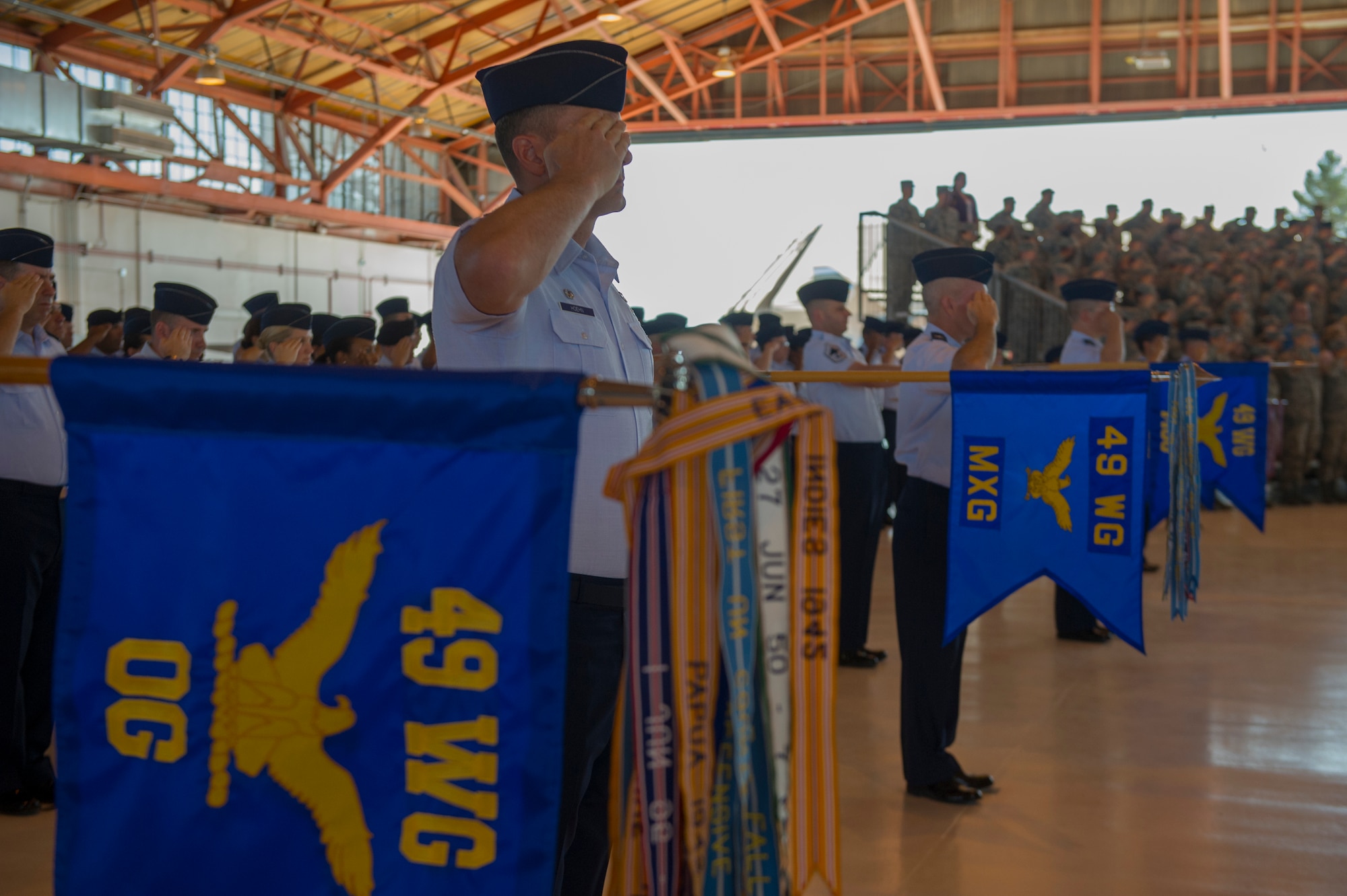 The 49th Wing stands at attention and salutes during an assumption of command ceremony at Holloman Air Force Base, N.M., July 18. An assumption or change of command is a military tradition that represents a formal transfer of authority and responsibility for a unit from one commanding officer to another. (U.S. Air Force photo by Airman 1st Class Aaron Montoya / Released)