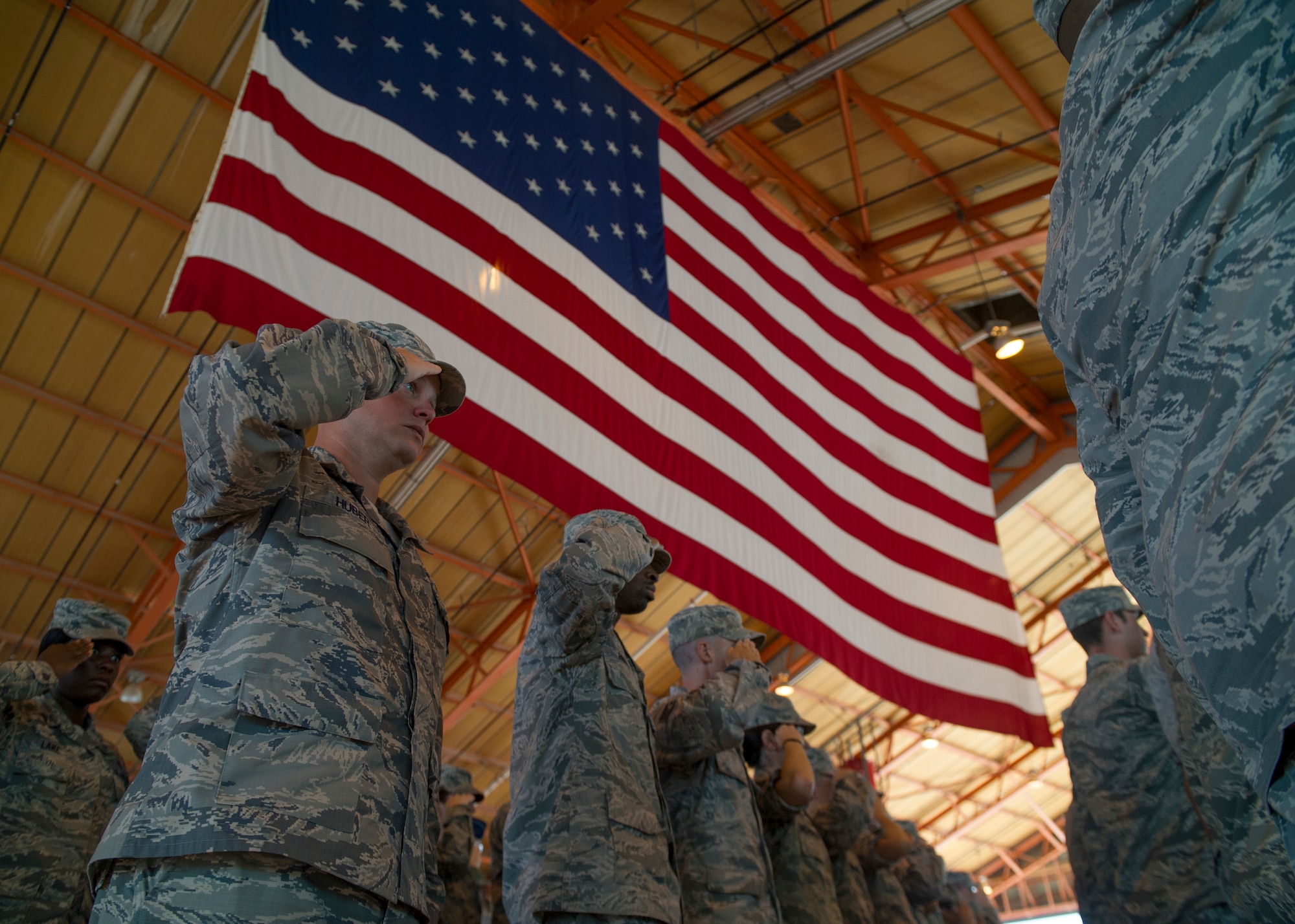 Airmen of the 49th Wing stand and salute the flag while the National Anthem plays during an assumption of command ceremony at Holloman Air Force Base, N.M., July 18. An assumption or change of command is a military tradition that represents a formal transfer of authority and responsibility for a unit from one commanding officer to another. (U.S. Air Force photo by Airman 1st Class Aaron Montoya / Released)