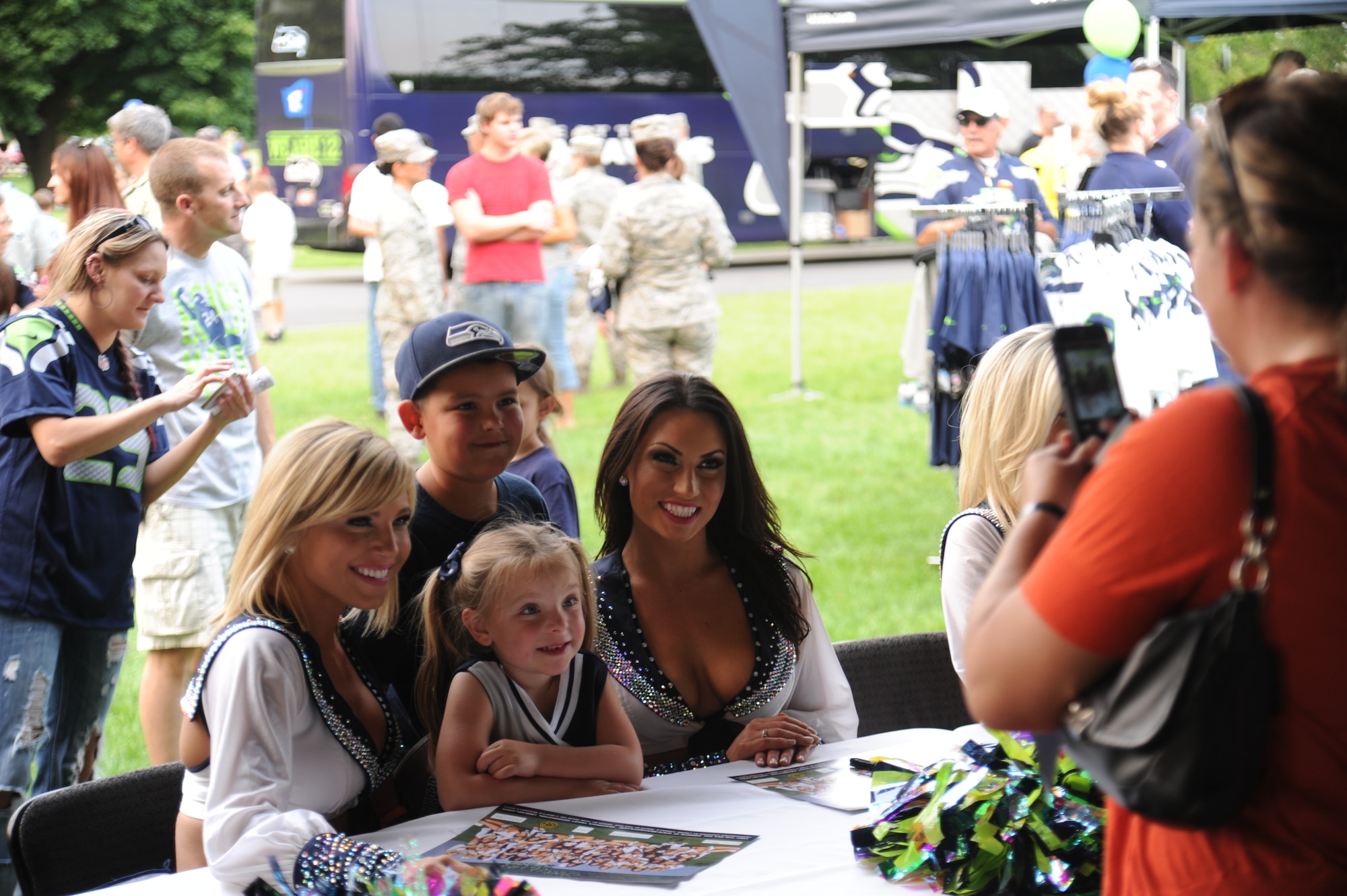 The Seagals cheerleaders pose for a photo with Seattle Seahawks fans during the ‘Heros of 12’ Military Appreciation Tour at Fairchild Air Force Base, Washington, July 17, 2014. The tour consists of Seahawk players, Seagals cheerleaders, the Blue Thunder Band, Taima the Hawk with falconer David Knutson, Blitz the official team mascot and the Lomabardi trophy. (U.S. Air Force photo by Airman 1st Class Janelle Patiño/Released)