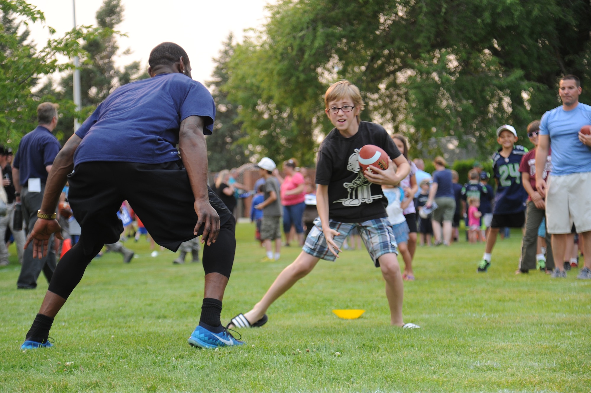 Ricardo Lockette plays with Team Fairchild during the ‘Heros of 12’ Military Appreciation Tour at Fairchild Air Force Base, Washington, July 17, 2014. Lockette plays with the Seahawks as a wide receiver. The tour consists of Seahawk players, Seagals cheerleaders, the Blue Thunder Band, Taima the Hawk with falconer David Knutson, Blitz the official team mascot and the Lomabardi trophy. (U.S. Air Force photo by Airman 1st Class Janelle Patiño/Released)