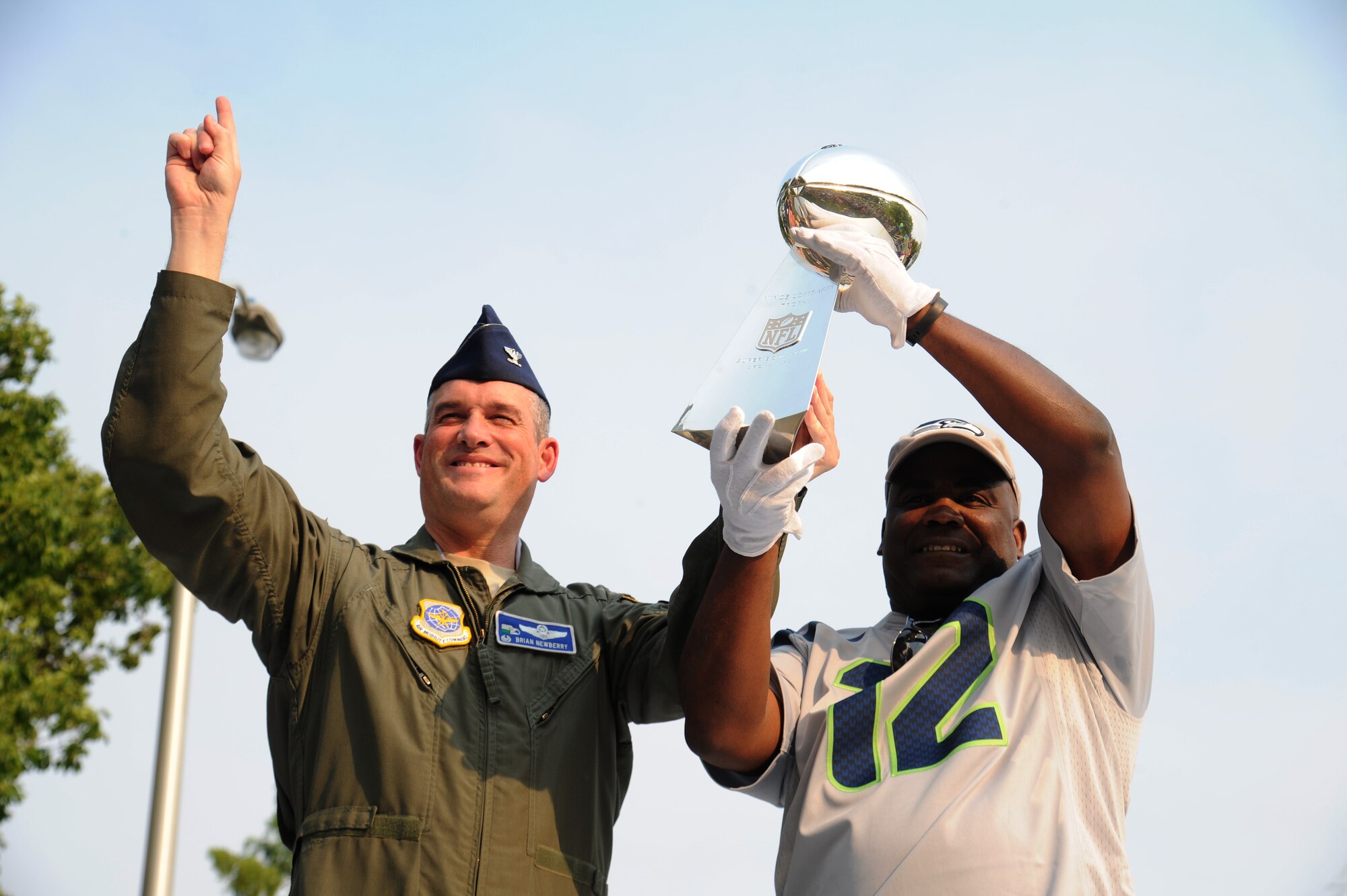Col. Brian Newberry and Michael Larkins hold up the Lomabardi trophy during the ‘Heros of 12’ Military Appreciation Tour at Fairchild Air Force Base, Washington, July 17, 2014. The purpose of the tour was to show appreciation for the U.S. Military and their families, for their sacrifices, dedication and service to our country. Newberry is the 92nd Air Refueling Wing commander. (U.S. Air Force photo by Airman 1st Class Janelle Patiño/Released)