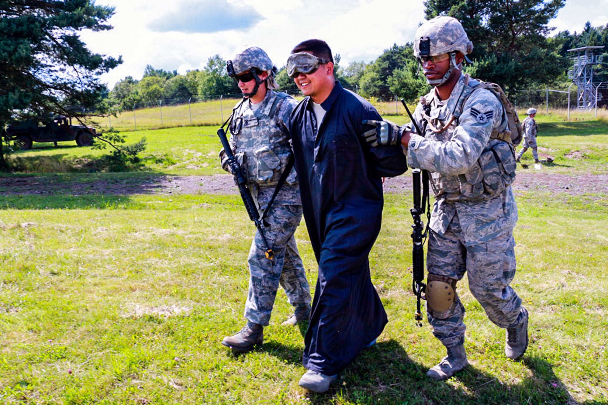 A 446th Security Forces Squadron Reservist from McChord Field, Washington is escorted by airmen during a training scenario July 16, near Baumholder, Germany. The Reservist was pretending to be a refugee who was caught breaking into the base while searching for food and water. The purpose of the training is to allow airmen to practice different scenarios they may face down range prior to deployment. (U.S. Air Force Reserve photo by Senior Airman Madelyn McCullough)