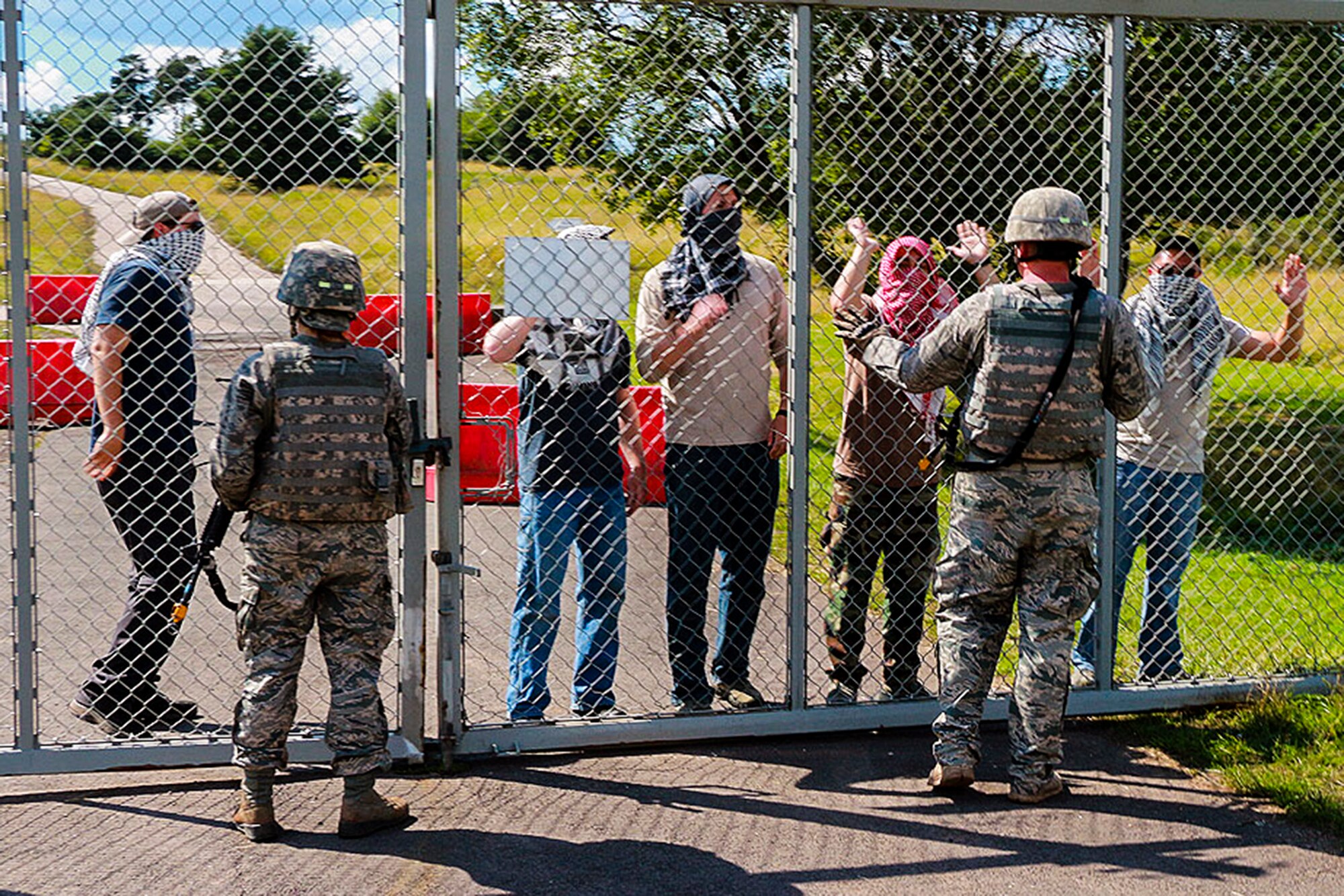 446th Security Forces Squadron Reservists from McChord Field, Washington threaten airmen during a training scenario July 16, near Baumholder, Germany. The Reservists were pretending to be a members of a terrorist organization demanding the Americans to leave.The purpose of the training is to allow Airmen to practice different scenarios they may face down range prior to deployment. (U.S. Air Force Reserve photo by Senior Airman Madelyn McCullough)