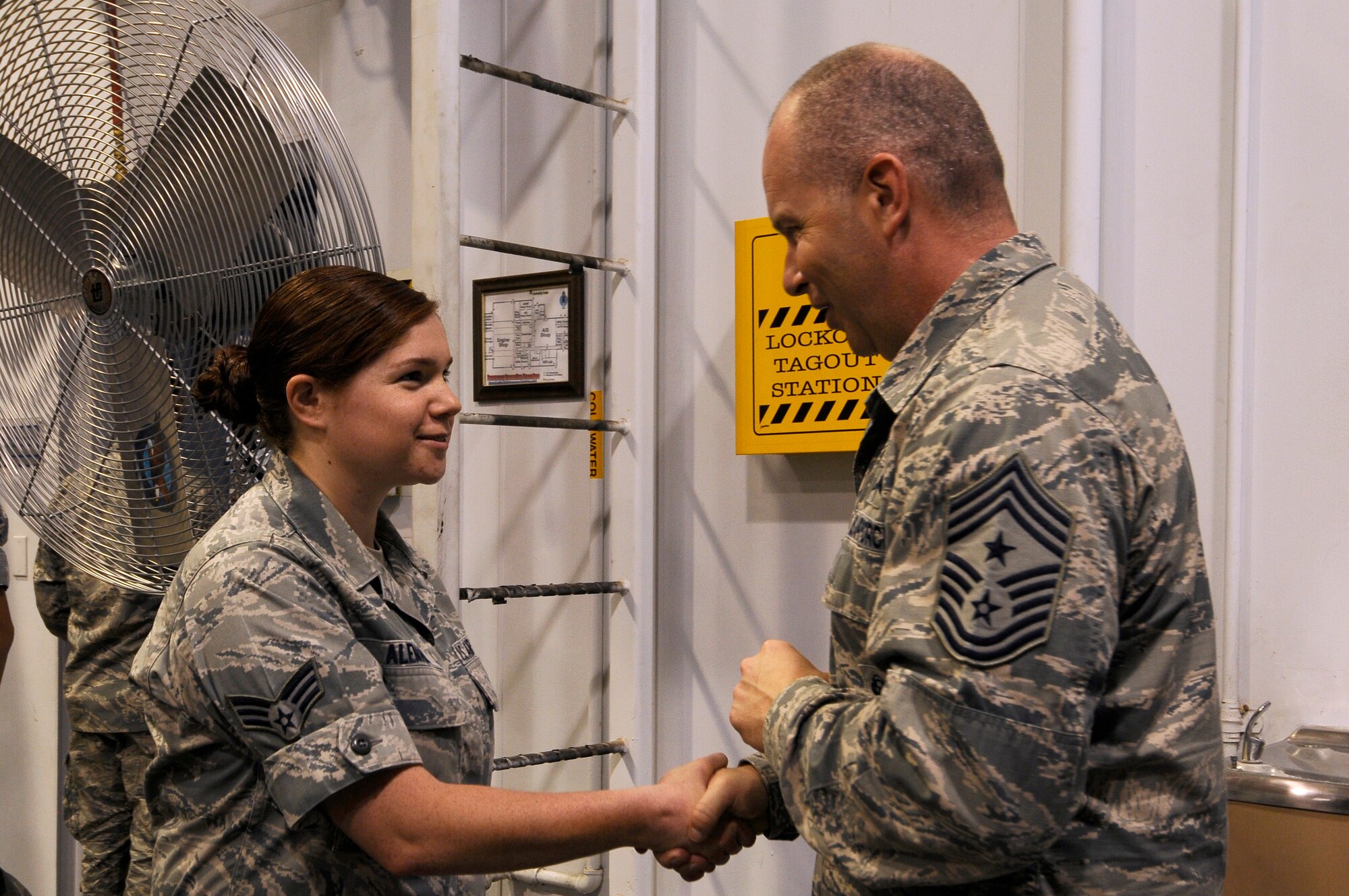 U.S. Air National Guard Command Chief Master Sgt. James W. Hotaling coins Senior Airman Micaelah Aleman, 144th Logistics Readiness Squadron logistics planner, during an all call held at the Fresno Air National Guard Base, Calif., July 13, 2014. Aleman was coined for her outstanding work she does in her unit and for the Wing as a whole.  (U.S. Air National Guard photo by Airman 1st Class Klynne Pearl Serrano/Released)