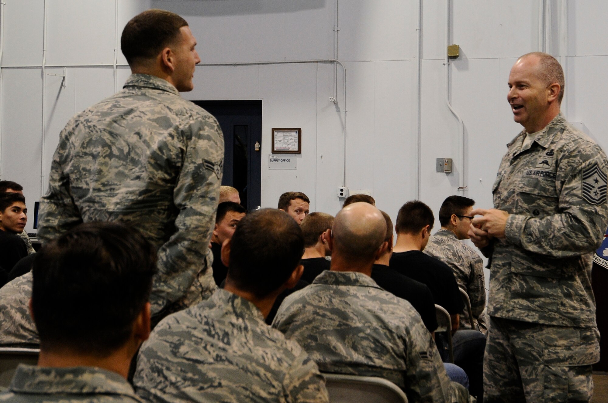 Airman 1st Class Russell Allen, 144th Civil Engineer Squadron firefighter, asks U.S. Air National Guard Command Chief Master Sgt. James W. Hotaling a question about the changes being made in the Air Force Basic Military Training during an all call held at the Fresno Air National Guard Base July 13, 2014.  (U.S. Air National Guard photo by Airman 1st Class Klynne Pearl Serrano/Released)