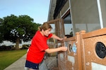 Chief Master Sgt. Dana Wood, Air Education and Training Command enlisted professional military education functional manager, uses a sponge to scrub off extra paint on park garbage cans during the Eberle Park Renovation project July 12 at Joint Base San Antonio-Randolph. The day’s mission included spreading mulch in playgrounds, adding sand to the outside volleyball court, power-washing, painting, and cleaning up. Volunteers were members of either the Randolph Top Three or Randolph Chief’s Group. (U.S. Air Force photo by Senior Airman Kenna Jackson)