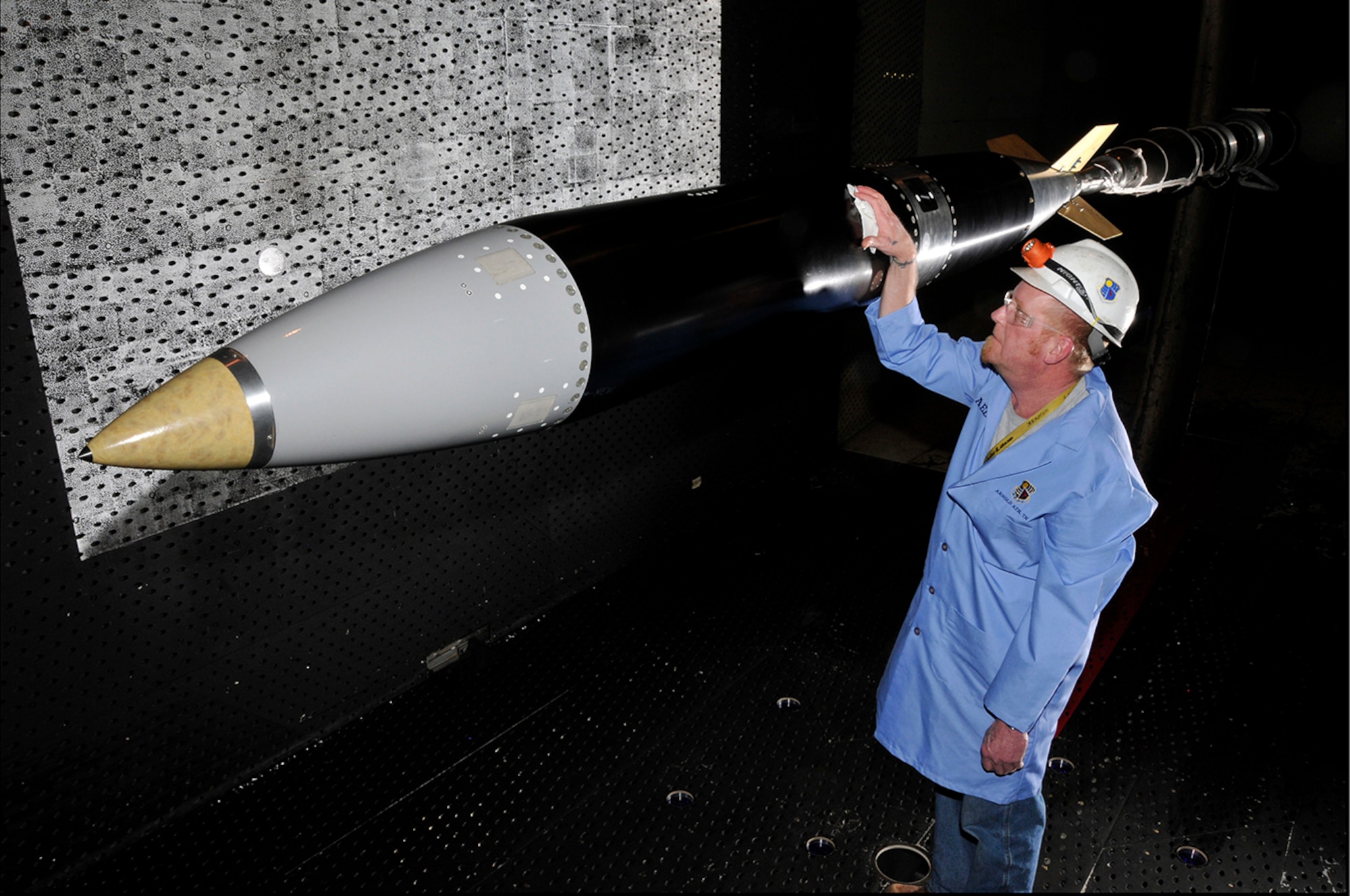 Arnold Engineering Development Complex (AEDC) engineers recently joined researchers with Sandia National Laboratories to perform a wind tunnel test on a full-scale mock-up B61. Pictured with the model is Gary Cunningham, an outside machinist for ATA. (Photo by Rick Goodfriend)
