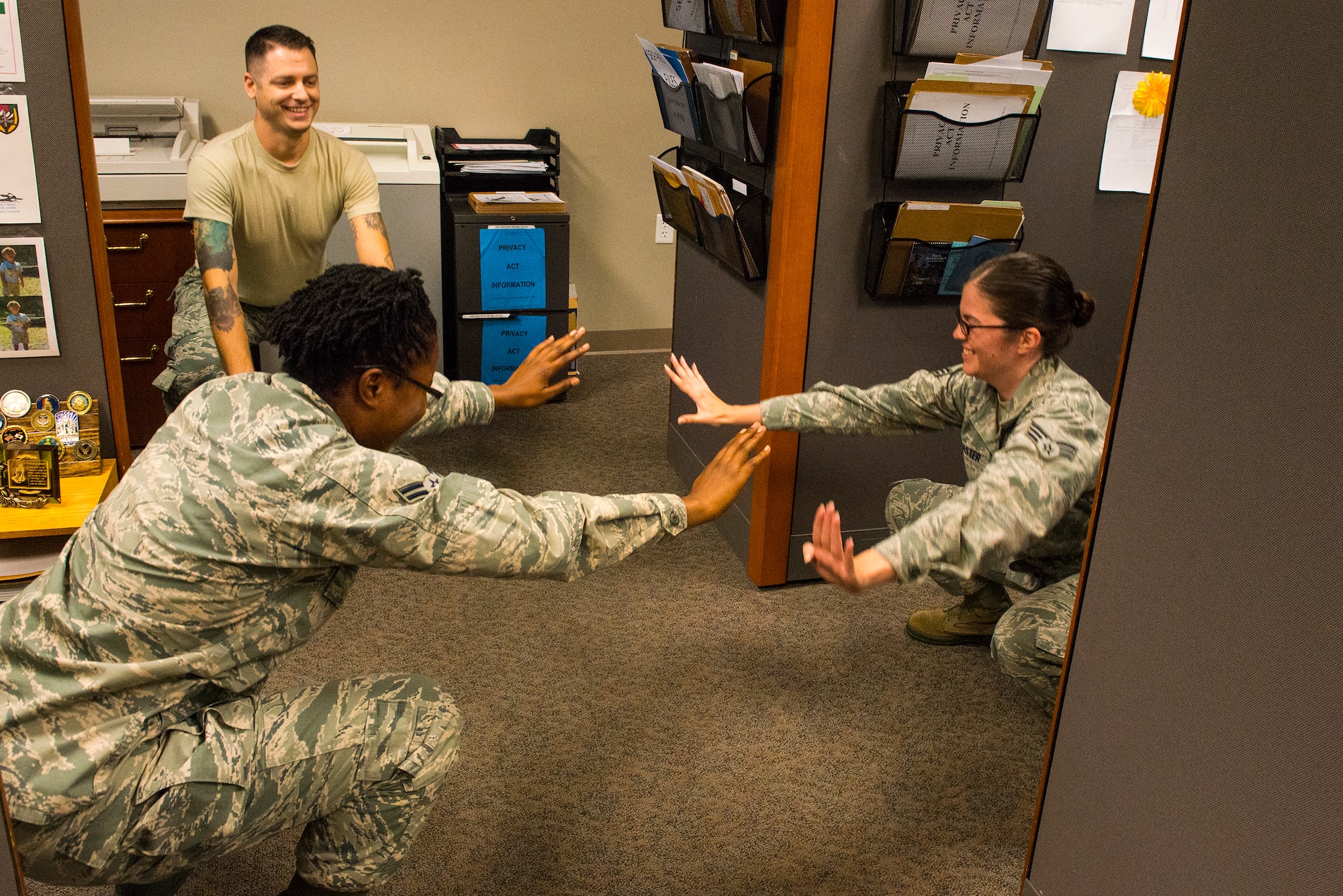 Airmen from the 23d Comptroller Squadron take a break from the job to perform squats at Moody Air Force Base, Ga., July 17, 2014. They are currently completing a 30-day squat challenge. (U.S. Air Force photo by Airman 1st Class Ceaira Tinsley/Released)