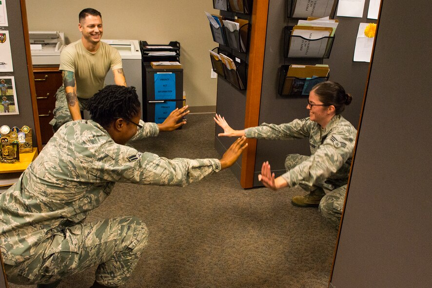 Airmen from the 23d Comptroller Squadron take a break from the job to perform squats at Moody Air Force Base, Ga., July 17, 2014. They are currently completing a 30-day squat challenge. (U.S. Air Force photo by Airman 1st Class Ceaira Tinsley/Released)