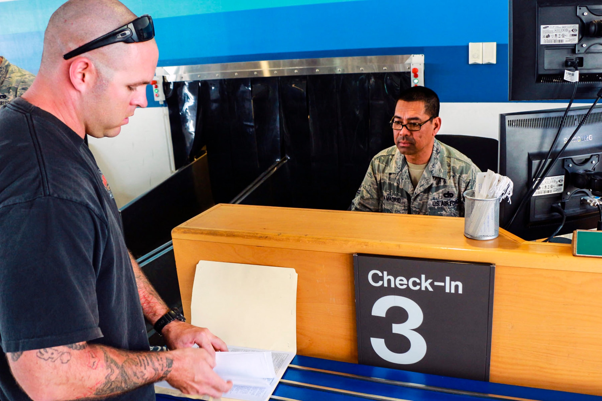 Tech. Sgt. Neri La Madrid, 36th Aerial Port Squadron passenger terminal specialist, helps a space available passenger July 15 at Ramstein Air Base, Germany. La Madrid is from the 446th Airlift Wing at McChord Field, Washington, and is participating in an annual training tour that will allow him to complete his training requirements. (U.S. Air Force Reserve photo by Senior Airman Madelyn McCullough)