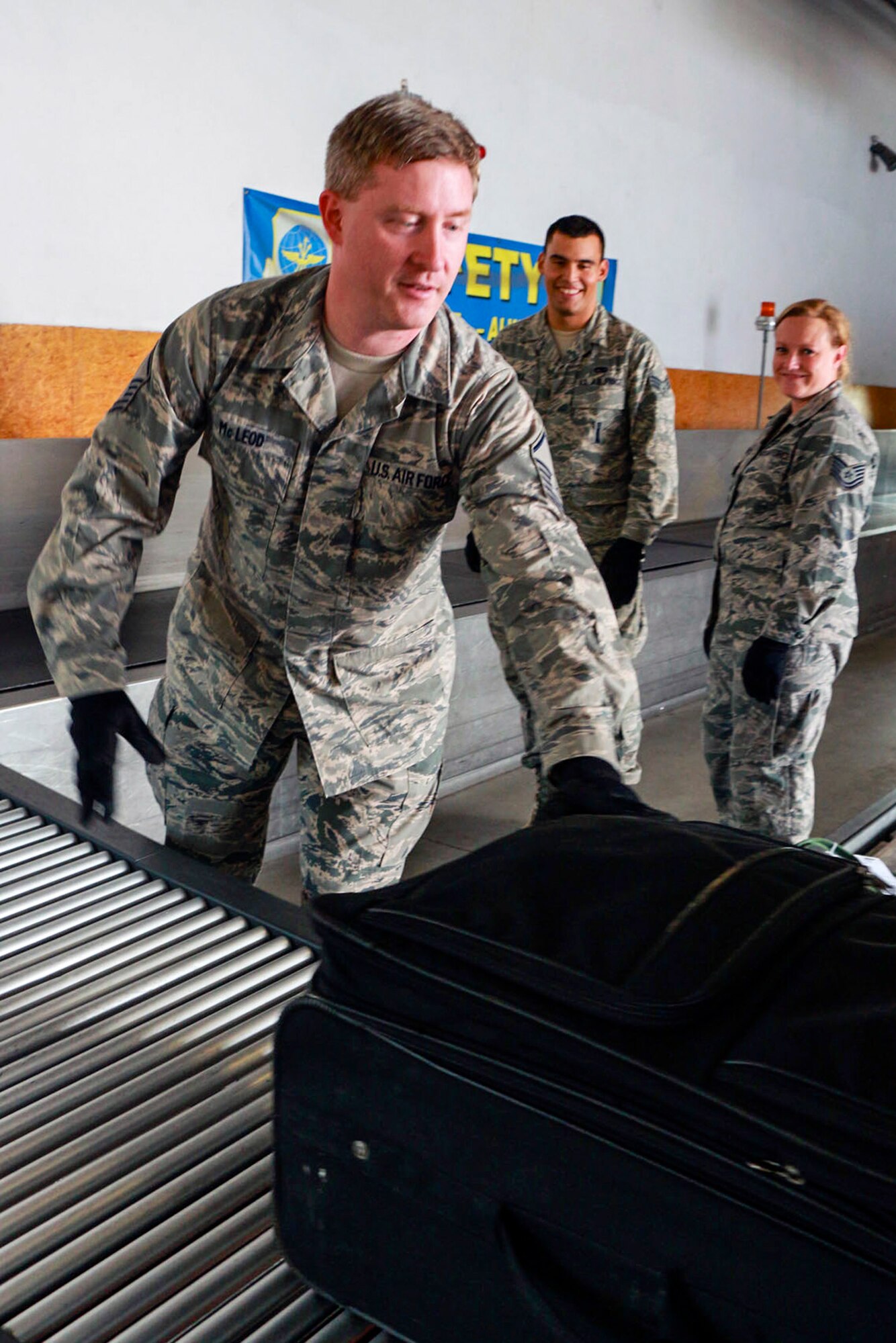 Master Sgt. Roderick Mcleod (foreground), Senior Airman Giovanny Parra (background left) and Tech. Sgt. Bonnie Thayne, 36th Aerial Port Squadron passenger terminal specialists, unload baggage after a flight has landed July 15 at Ramstein Air Base, Germany. These Reservists  from the 446th Airlift Wing at McChord Field, Washington, are participating in an annual training that will allow them to practice and improve their skill sets. (U.S. Air Force Reserve photo by Senior Airman Madelyn McCullough)