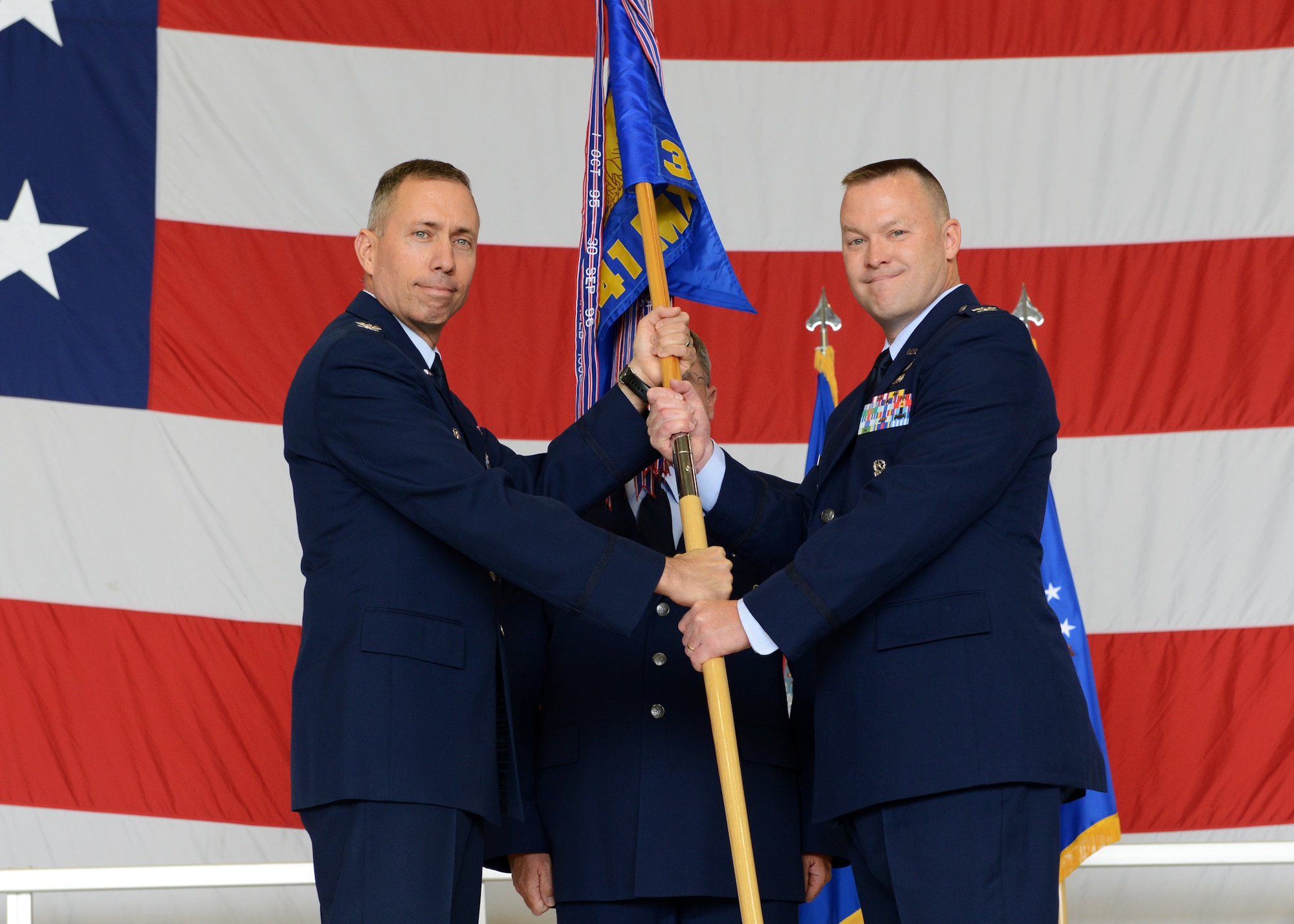 Col. Kenneth Speidel (right), accepts command of the 341st Munitions Squadron from Col. Tom Wilcox, 341st Missile Wing commander, at the Maintenance 3-Bay July 18 during a change of command ceremony. Col. David Lair was the relinquishing commander. (U.S. Air Force photo/Senior Airman Katrina Heikkinen)