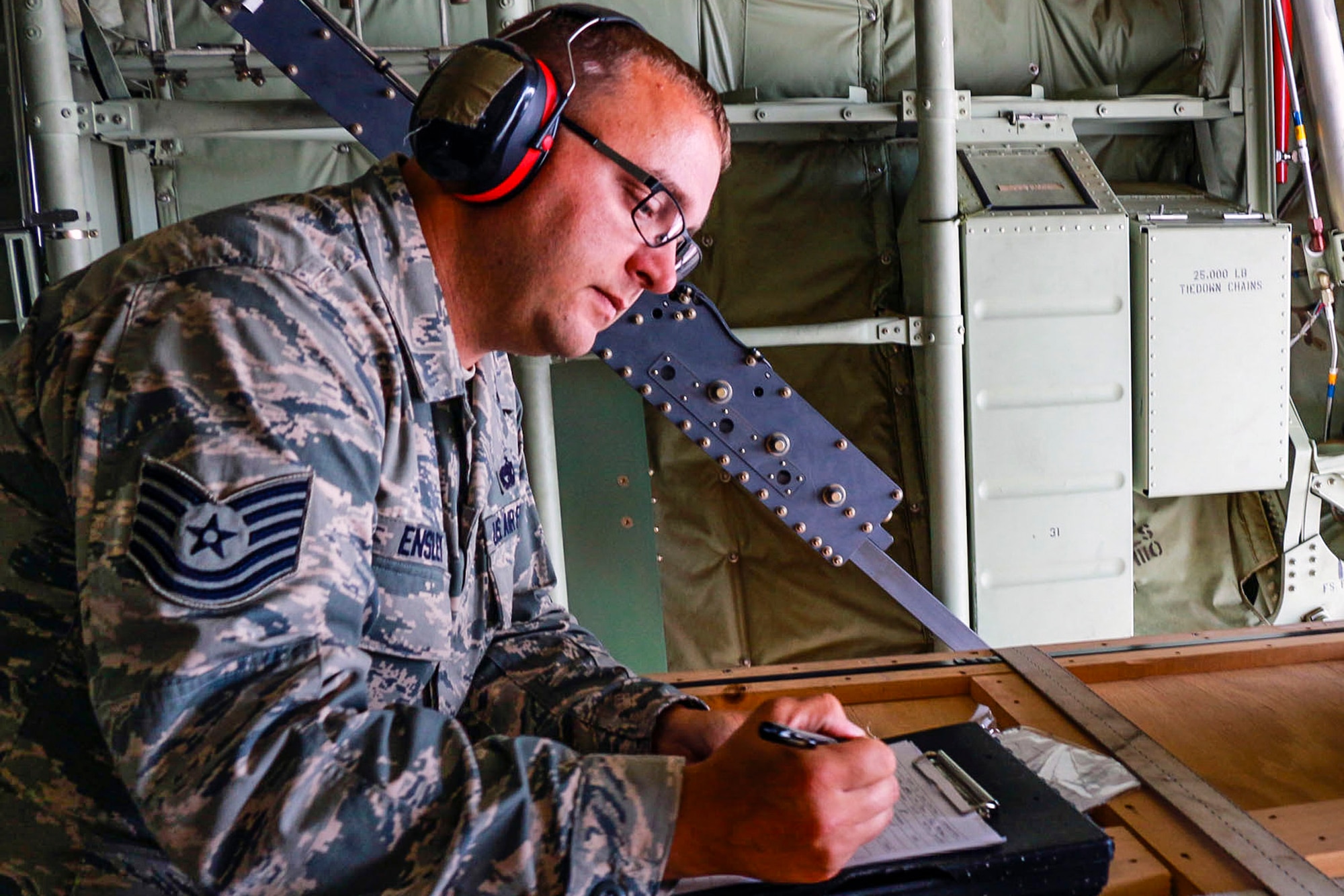 Tech. Sgt. Shawn Ensley, 36th Aerial Port Squadron air traffic operations controller, records weights and destinations of cargo on a C-130 Hercules aircraft after arrival July 15 at Ramstein Air Base, Germany. Ensley is a Reservist from the 446th Airlift Wing at McChord Field, Washington and is in Germany working with active duty during his annual training. (U.S. Air Force Reserve photo by Senior Airman Madelyn McCullough)