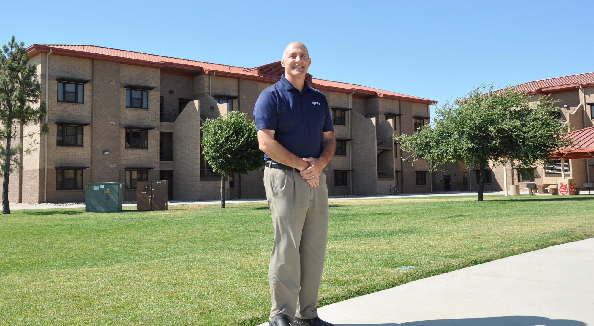 David Schenone, consultant for a cable company the serves Travis Air Force Base, poses for a photo July 8, 2013 outside of the new dormitories. Schenone contributed to the installation of the majority of the cable for Airmen in the dorms at Travis. (U.S. Air Force photo by Airman 1st Class Amber Carter/Released)