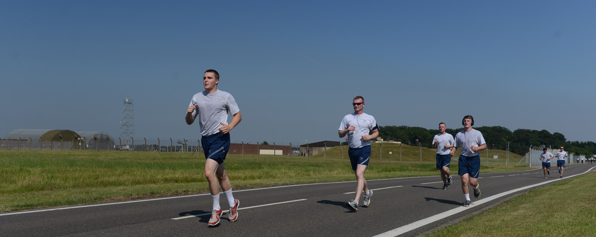 Team Mildenhall members jog along the base perimeter during the monthly 5 km run July 18, 2014, on RAF Mildenhall, England. The monthly 5 km run encourages morale and camaraderie throughout the base. (U.S. Air Force photo/Airman 1st Class Preston Webb/Released)