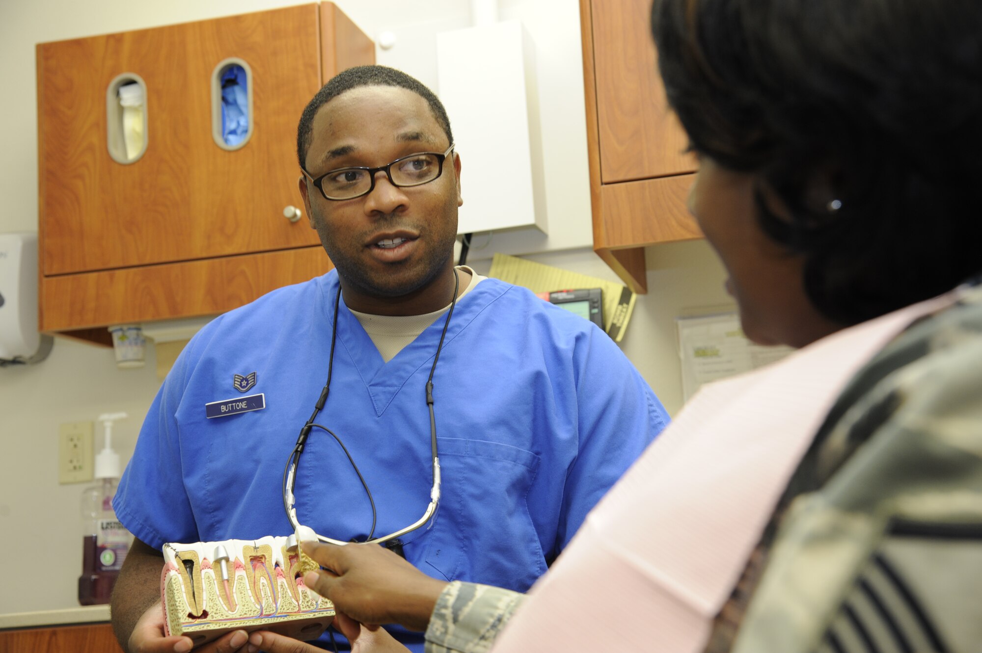 Staff Sgt. Christopher Buttone, 47th Medical Operations Squadron NCO in charge of dental logistics, gives an explanation on cavities at the Laughlin Medical Clinic on Laughlin Air Force Base, Texas, July 16, 2014. Buttone was one of 47 active duty Air Force members selected from a pool of 78, for the Nurses Enlisted Commissioning Program. (U.S. Air Force photo by Airman 1st Class Jimmie D. Pike)(Released)