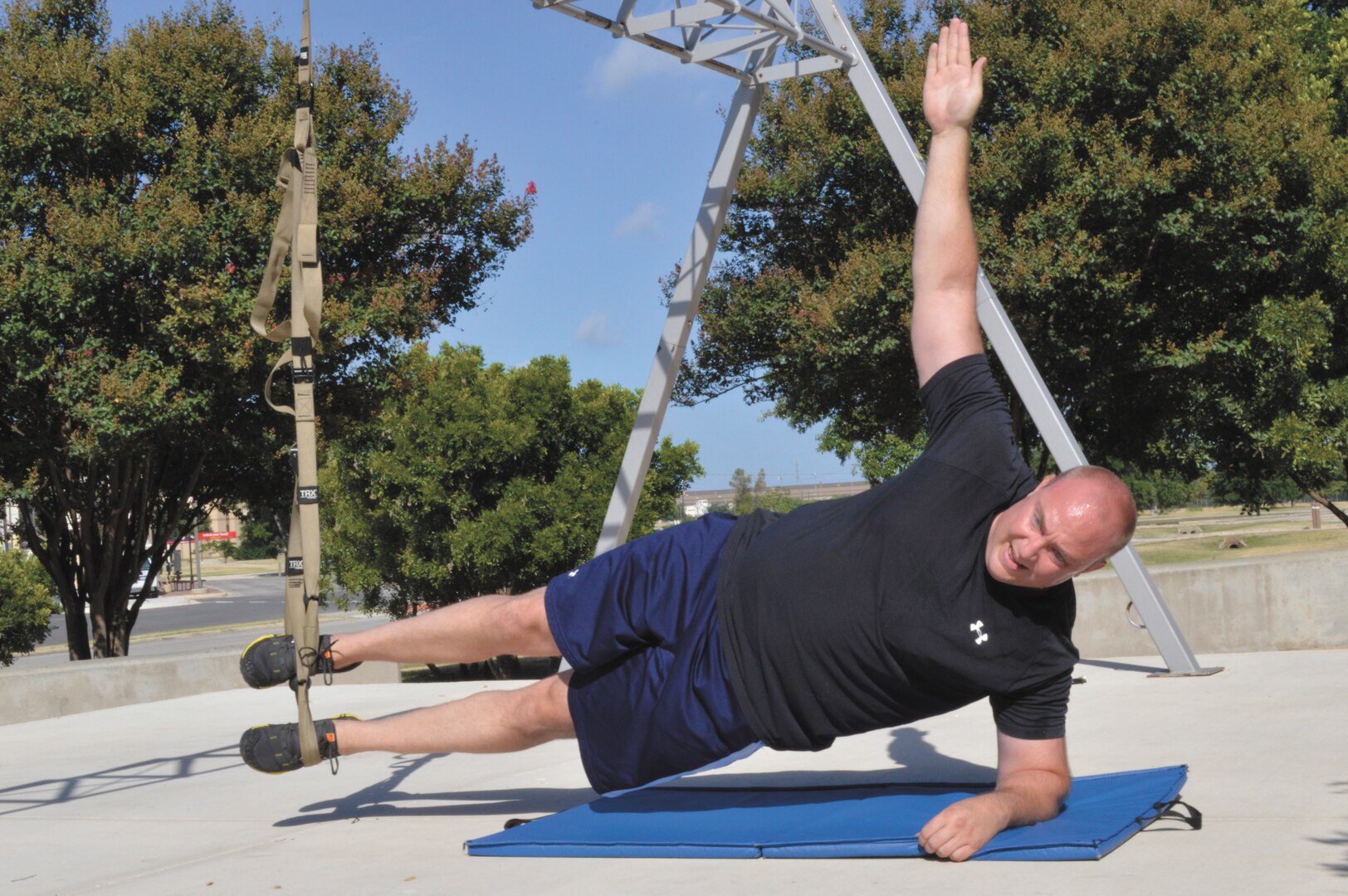 Tech Sgt. James Cummings, 668th Alteration and Installation Squadron NCO in charge of engineering installation, performs a static oblique side raise using TRX training equipment July 8 at the Gateway Fitness Center. ( Photo by Jose T. Garza III)
