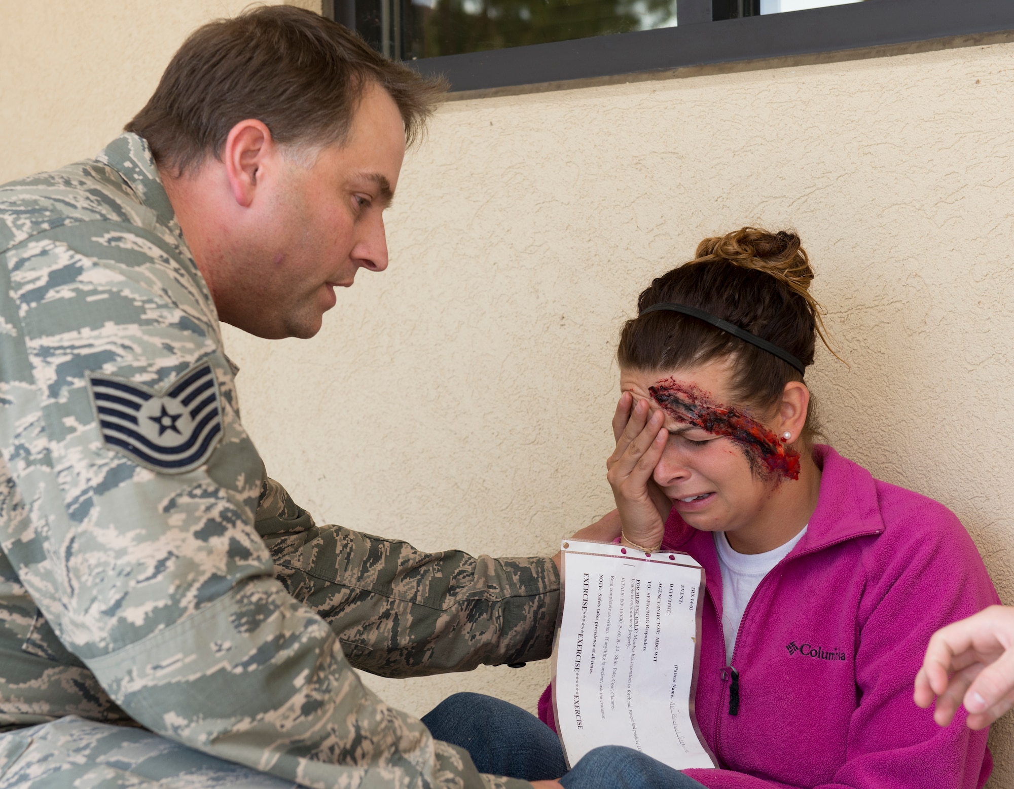 Tech. Sgt. Christopher Thomas, left, attends to a mock victim July 15 at Travis Air Force Base in the breezeway of Bldg. 243, which simulated a collapse due to an earthquake during a Travis Response Exercise. Members of the 60th Communication Squadron and Travis first responders rendered first aid to the  injured. (Released - U.S. Air Force Photograph/Heide Couch)