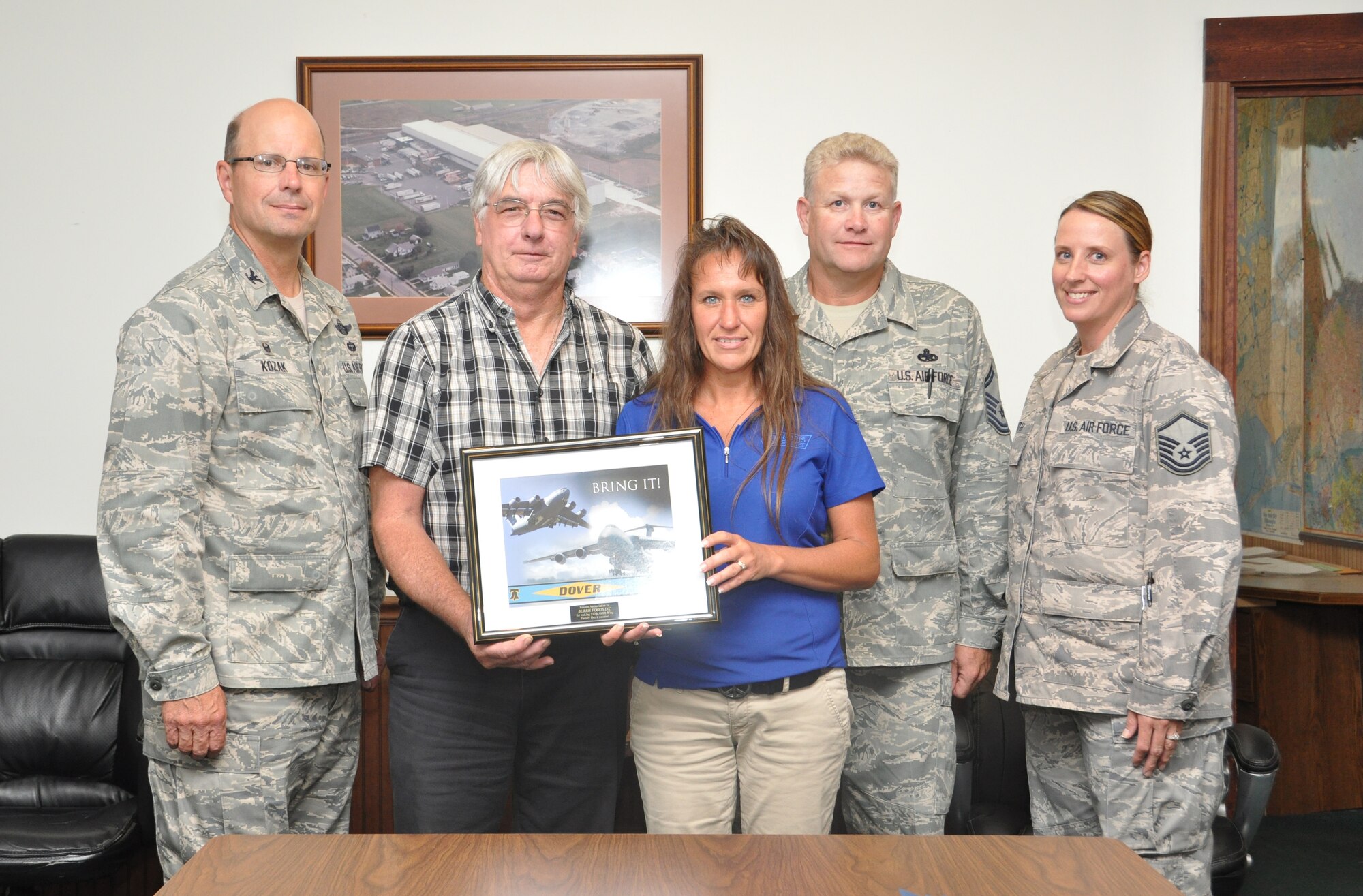 Col. Ramyond A. Kozak (left), 512th Airlift Wing commander, joins Senior Master Sgt. Ralph Ritter, 512th Aircraft Maintenance Squadron, and Master Sgt. Gina Huth, 512th AW, in presenting an inscribed picture of appreciation to John Bunting and Tina Hawkins, two Burris Logistics employees, in Harrington, Del., July 17, 2014. The temperature-controlled logistics company fulfilled a no notice, emergency need for a refrigeration truck at the Reserve unit's Wingman Day Picnic, attended by more than 1,500 Airmen and their families. (U.S. Air Force photo/Staff Sgt. Mercedes Crossland)  