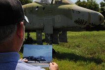 Michael Gorman, former Air Force crew chief, compares a picture of his first plane, "Miss Piggy," at Barksdale Air Force Base, La., July 7, 2014. Gorman crewed the A-10A Thunderbolt II with the 358th Aircraft Maintenance Unit at Davis-Monthan Air Force Base, Ariz., from 1979 to 1983, and found her after more than three decades apart. (U.S. Air Force photo/Staff Sgt. Jason McCasland)