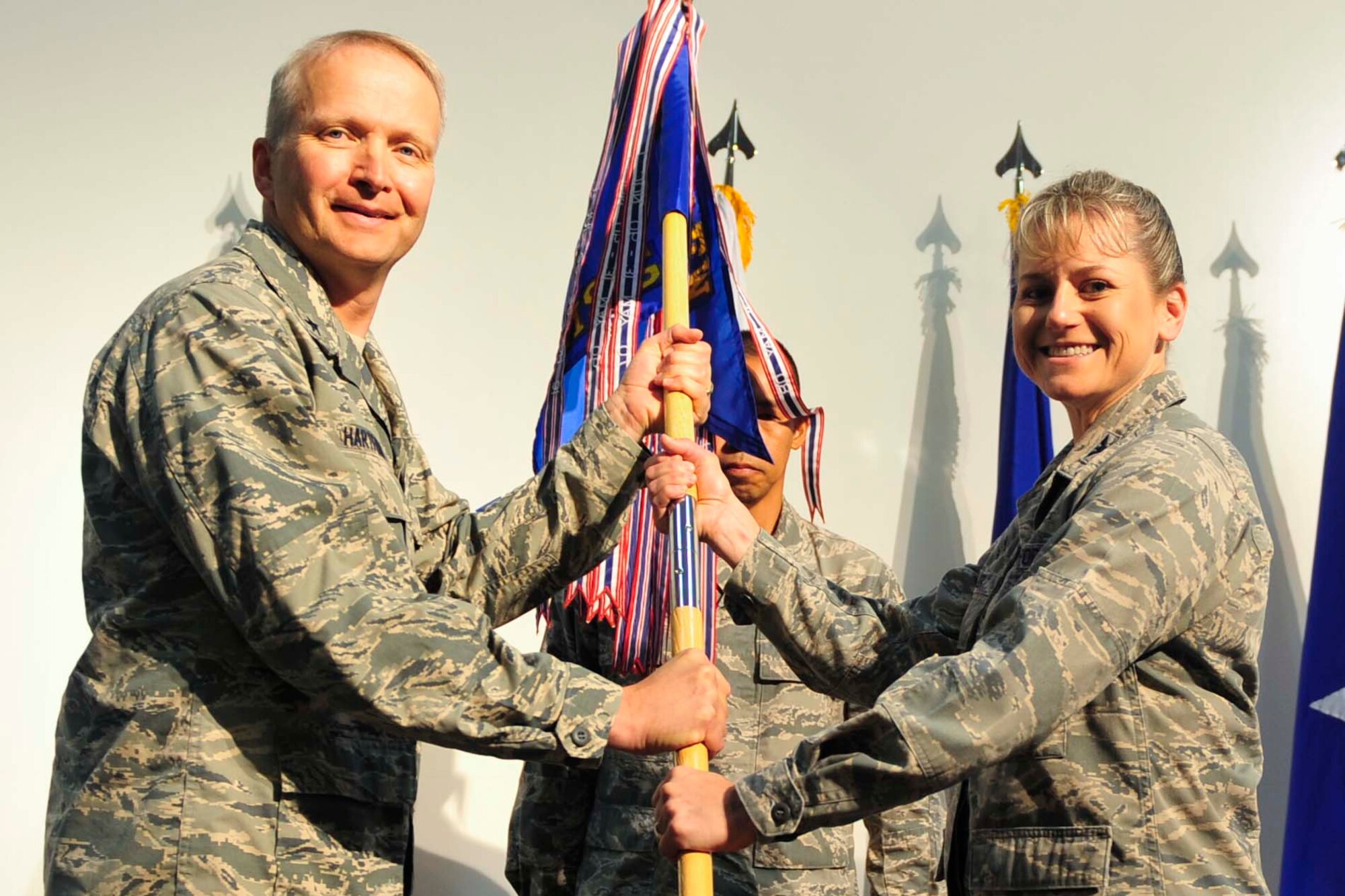 U.S. Air Force Col. Caroline Miller, 379th EMSG commander accepts the 379th Expeditionary Mission Support Group’s guidon from  Brig. Gen. Darren Hartford, 379th Air Expeditionary Wing commander, during a change of command ceremony at Al Udeid Air Base, Qatar, July 13, 2014. The group is the home to the 379th Expeditionary Logistics Readiness Squadron, 379th Expeditionary Communications Squadron, 379th Expeditionary Contracting Squadron, 379th Expeditionary Security Forces Squadron, 379th Expeditionary Civil Engineer Squadron and the 379th Expeditionary Force Support Squadron. (U.S. Air Force photo by Senior Airman Colin Cates)